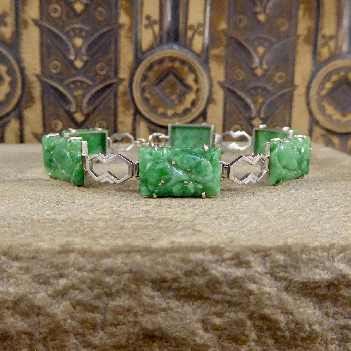 This gorgeous Art Deco bracelet features 6 panels of natural jade throughout with 9ct White Gold links between. The rectangular Jadeites are carved in a floral pattern, each one has three or four small holes through each panel as part of the floral