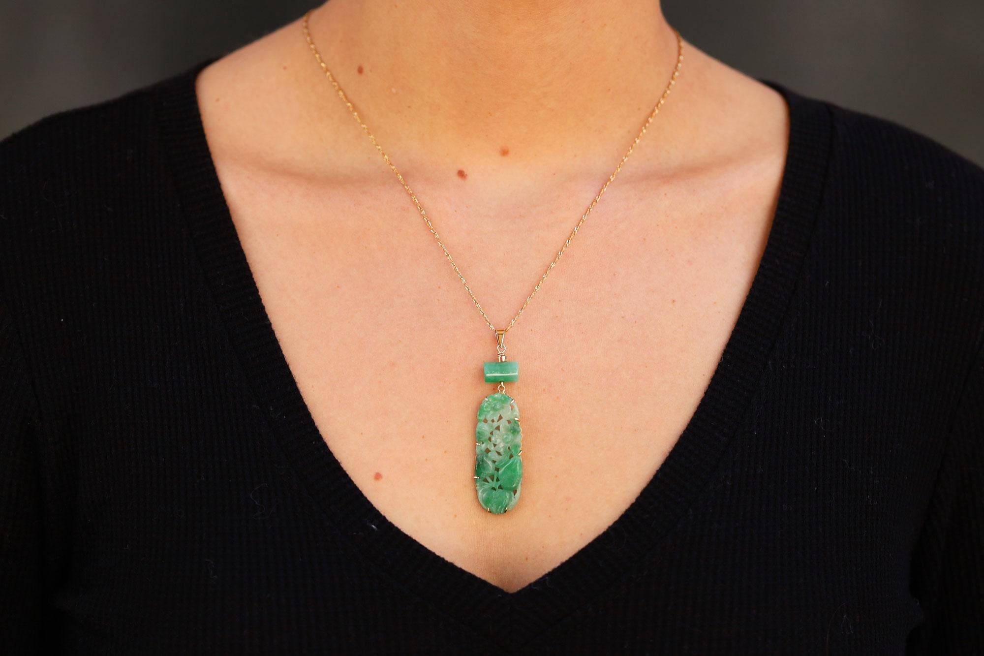 The central natural jadeite jade in this delightful drop necklace boasts a vibrant, mottled green color in an undulating oval carving. The piercings allowed their Chinese owners to sew these amulets on clothing to boast their status and wealth as