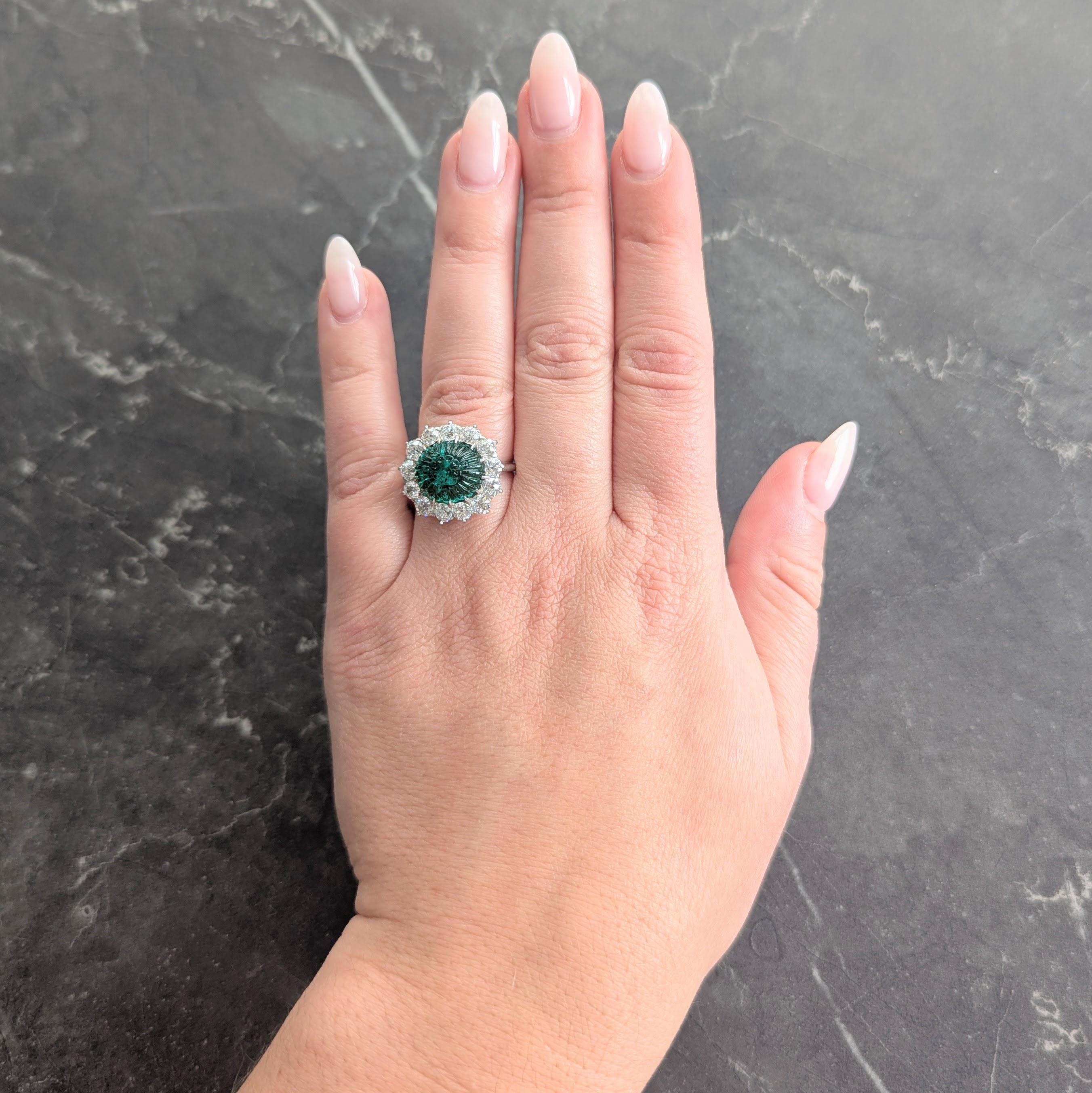 Al centro uno smeraldo cabochon di forma ovale del peso totale di circa 3.76 carati.
Trasparente di colore verde medio e intagliato in stile 'Mogul' con motivi floreali.
Incastonato in platino con un'aureola di diamanti di taglio transitorio
Peso