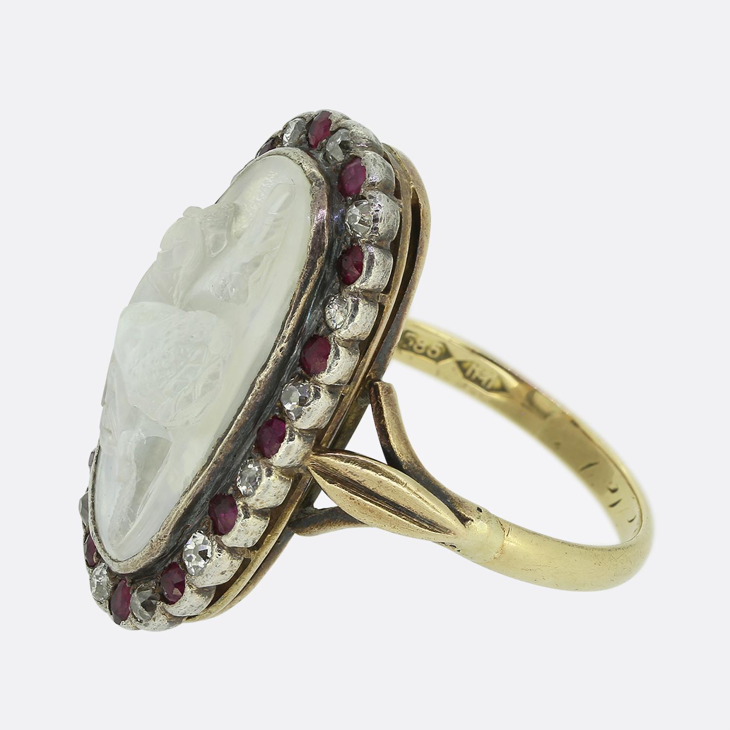 Here we have a rare and wonderful ring dating back to the 1930s The ring features a central carved moonstone depicting what we believe to be the Greek god Apollo with his lyre. Surrounding the central moonstone there is a border of beautiful old cut