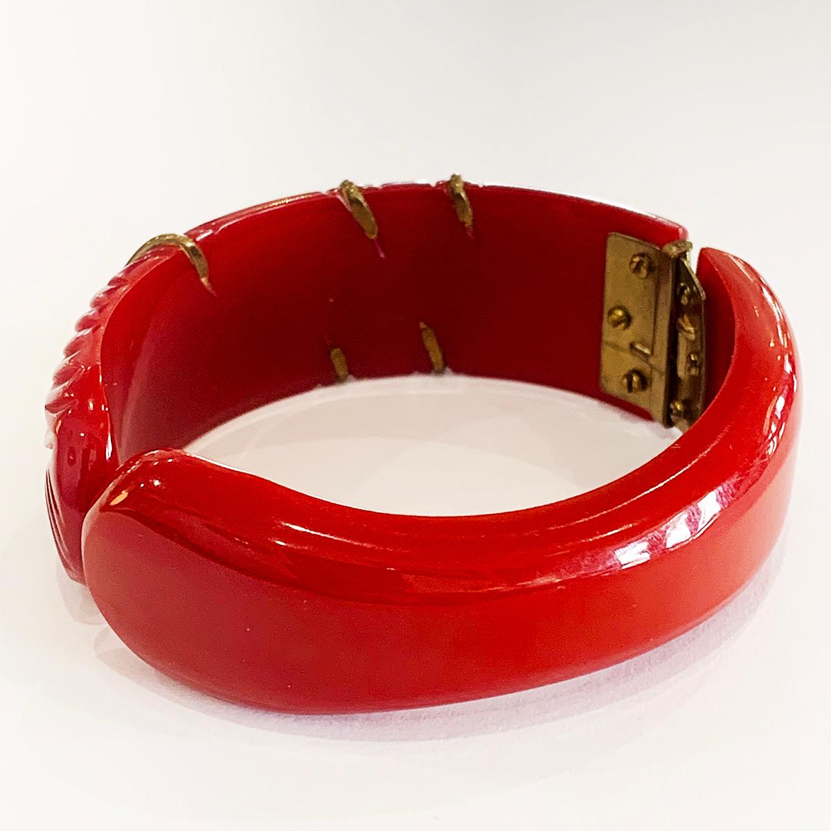 Art Deco Carved Red Bakelite with Gilt Bronze Flower, Leaf and multiple bands to the carved recesses. Typical Deco Asymmetrical Carvings offset to one side of bangle. All attachments, bands, etc., are pinned or rivetted and multi tiny screws to