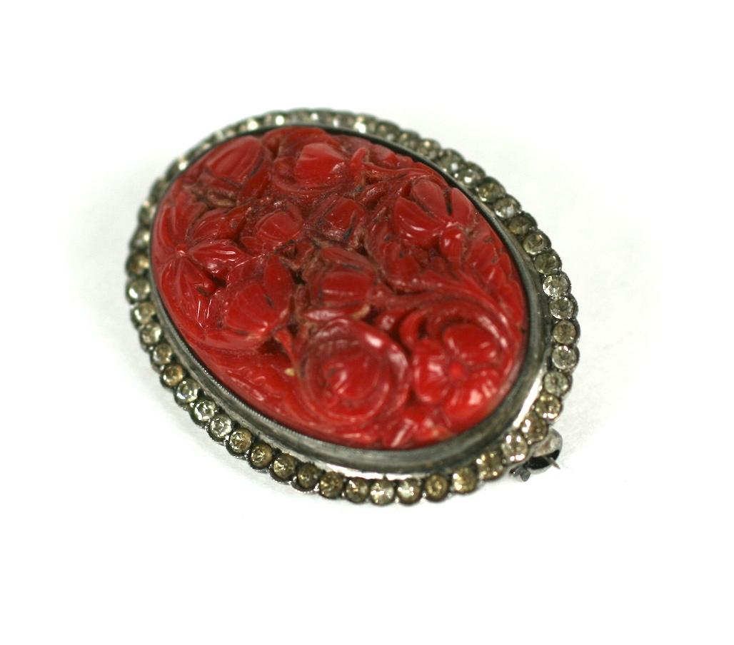  Art Deco carved genuine red coral and crystal paste brooch set in 800 grade silver mounting. The oval domed brooch is carved and pierced in a swirling floriform motif.  European circa 1910. 
1.5