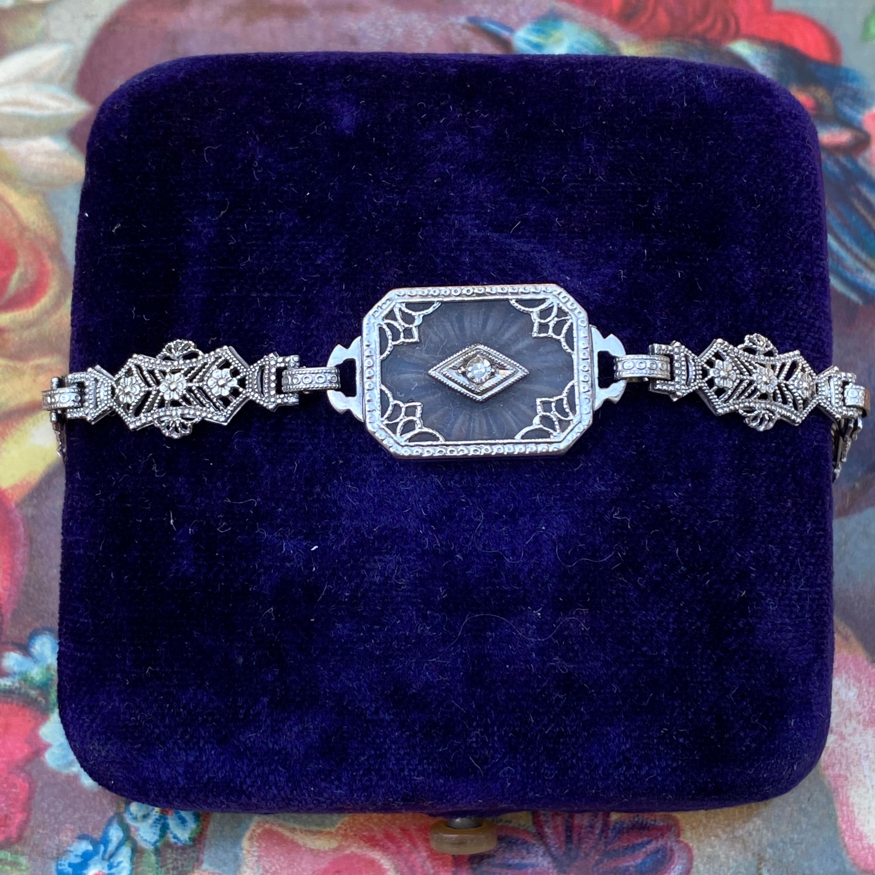 Détails :
Magnifique et délicat bracelet Art déco en cristal de roche sculpté filigrané en or blanc 10K des années 1920 avec diamant. Le diamant est rond de 2 mm. Le cristal de roche, souvent utilisé pendant la période Art déco, est dépoli d'un côté