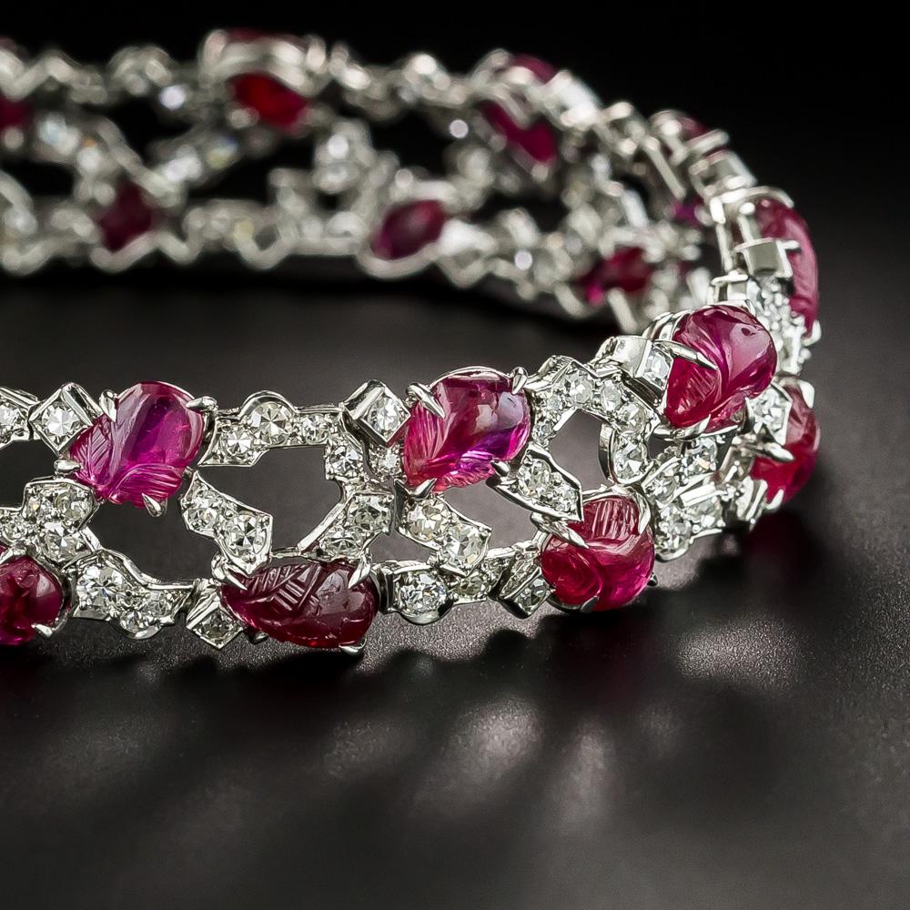 In this chic, sophisticated, and stunning Jazz Age jewel, twenty bright translucent red rubies - hand-carved in a decorative fruit motif - gleam from within a free-form geometric array of bright-white and sparkling single-cut diamonds secured by a