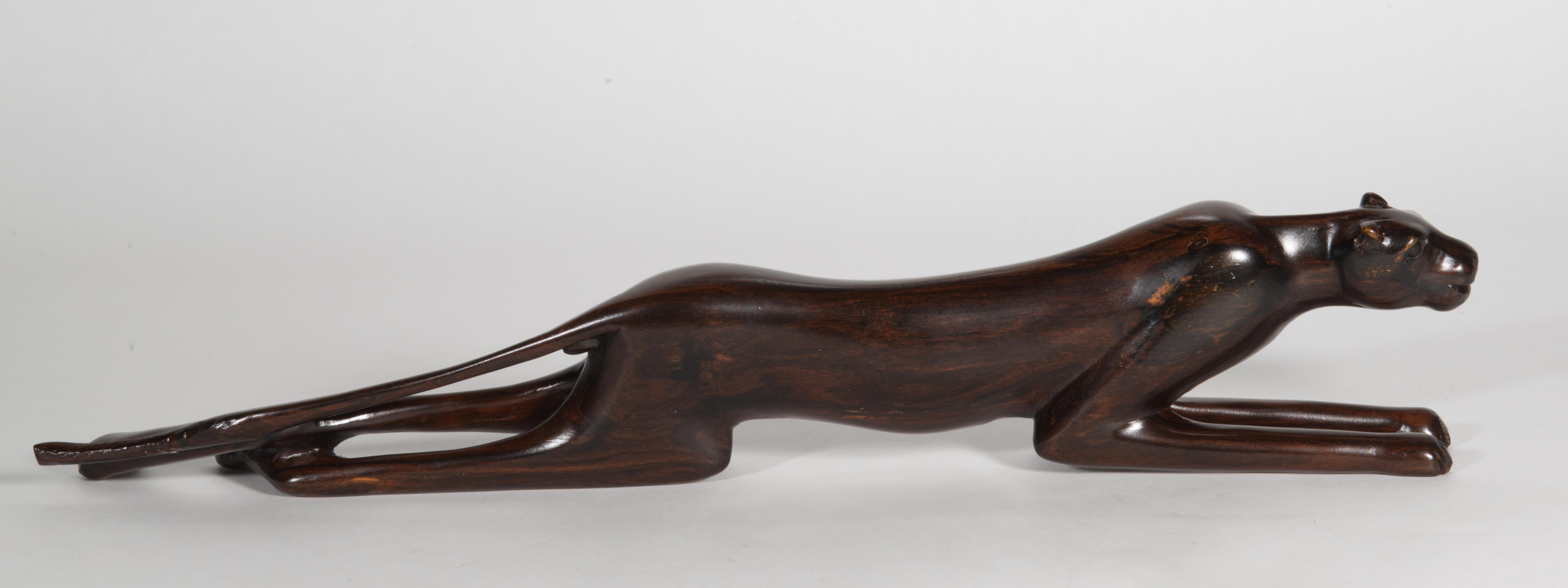 Cette élégante sculpture en bois sculpté de style Art déco représente une panthère allongée, tranquillement étendue, mais prête à sauter et à bondir. Un choix judicieux de bois d'ébène Macassar massif apporte un magnifique grain de bois et une