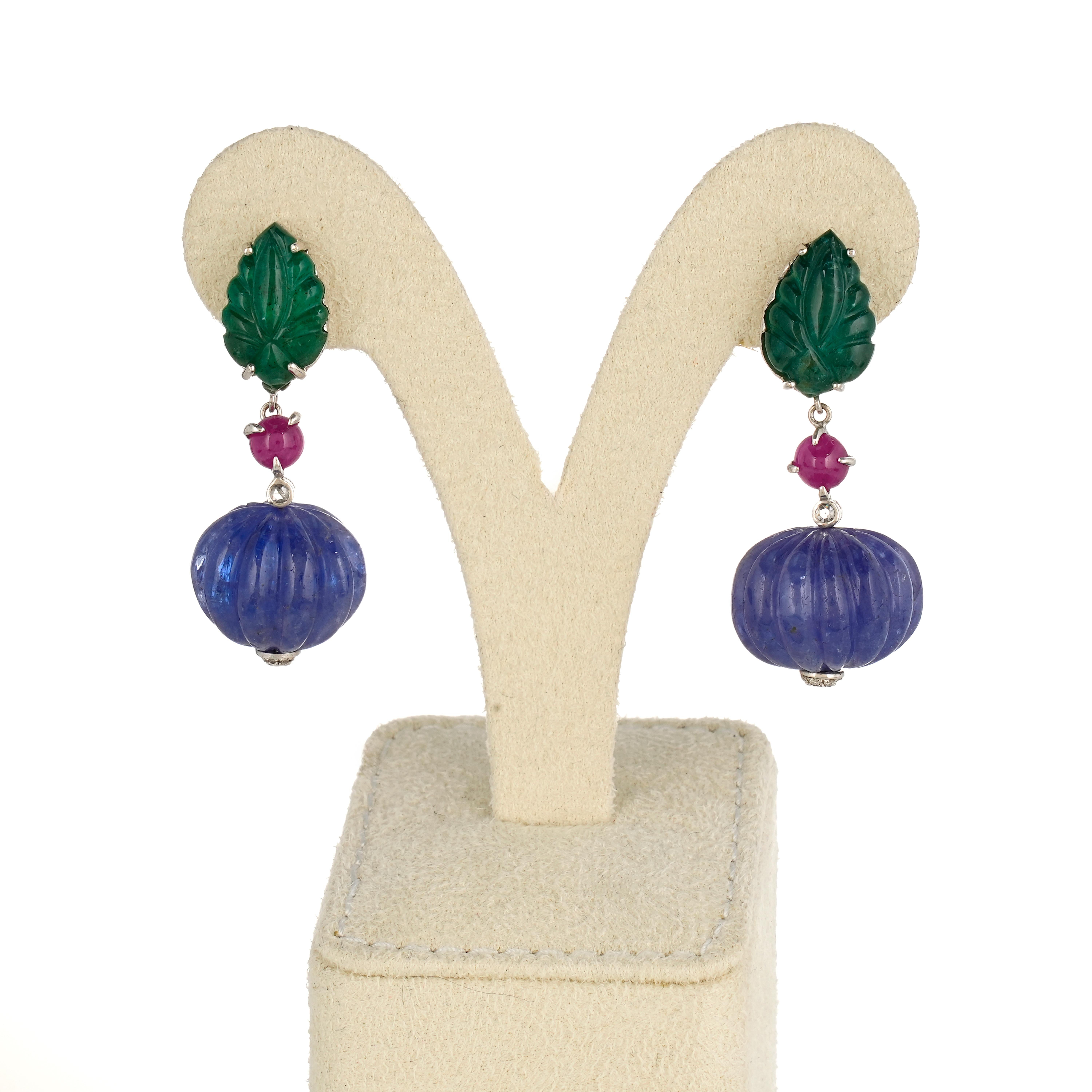 A beautifully crafted, art-deco looking 98.41 carat Tanzanite and 14.69 carat Emerald dangle earrings, with 2.64 carat Ruby and 0.08 carat Diamond, all set in solid 18K White Gold. The earrings come with a push-pull backing. 

Details:
Gold 18K: