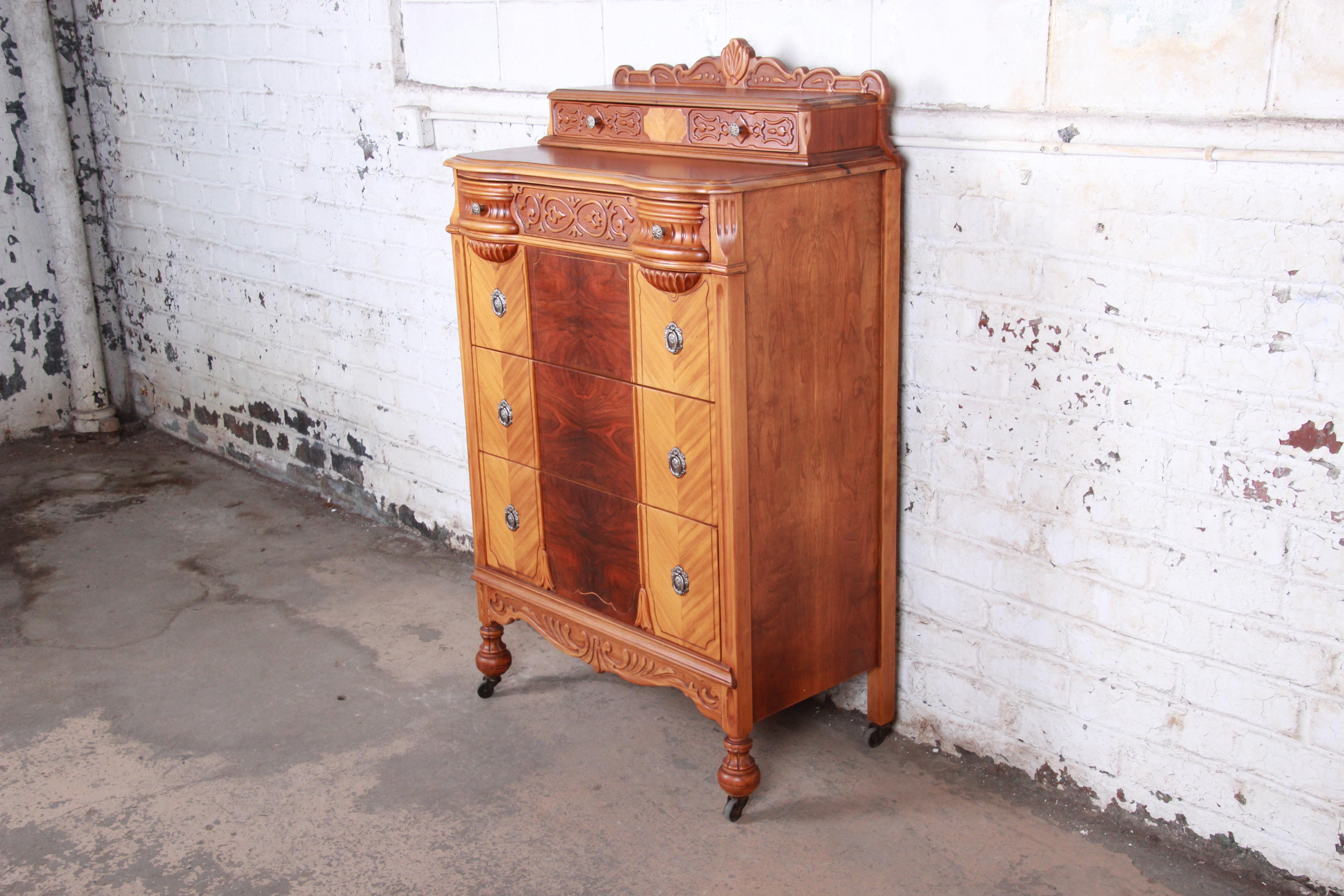 A gorgeous Art Deco ornate carved walnut highboy dresser

USA, 1930s

Carved walnut and book-matched burled walnut drawer fronts

Measures: 34.5