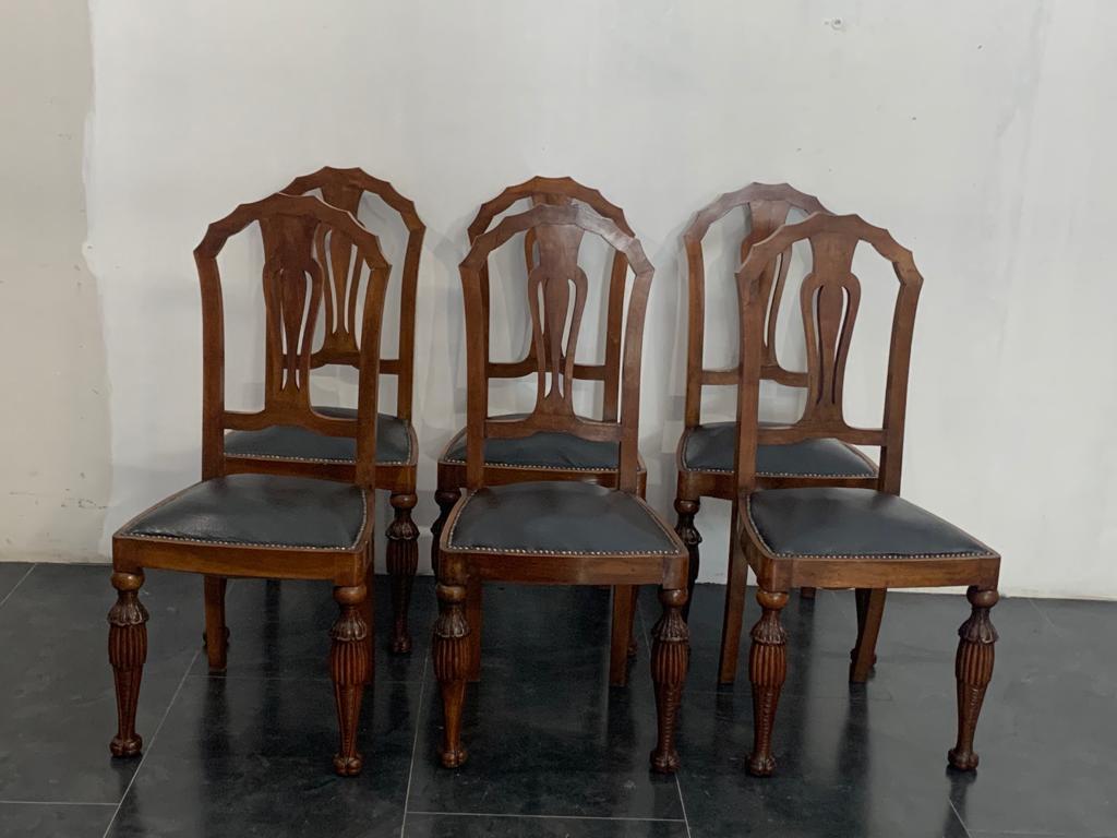 6 Art Deco chairs, leather seat. Back in walnut feather veneer and fan-shaped molding. The richly carved legs start with a sphere resting on a skirt carved with leaves next to it that opens onto a generously thick breadstick that leaves the leg that