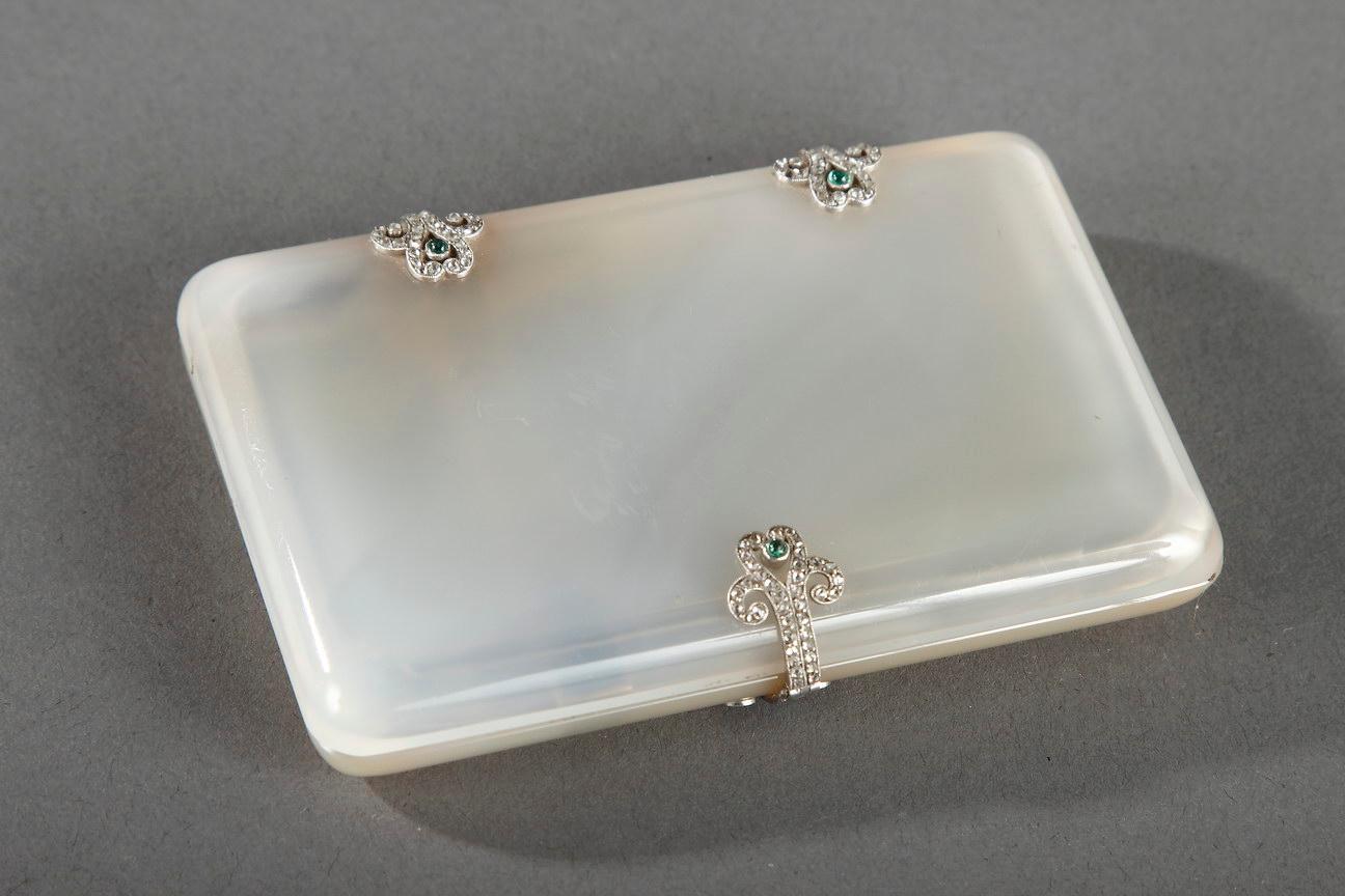 Translucent agate cigarette or card case with golden tints. The hinges and clasp in white gold with interlaced patterns are set with diamonds and emeralds on one side.
In the 1920s and '30s, smoking was regarded as a sophisticated pastime. Many