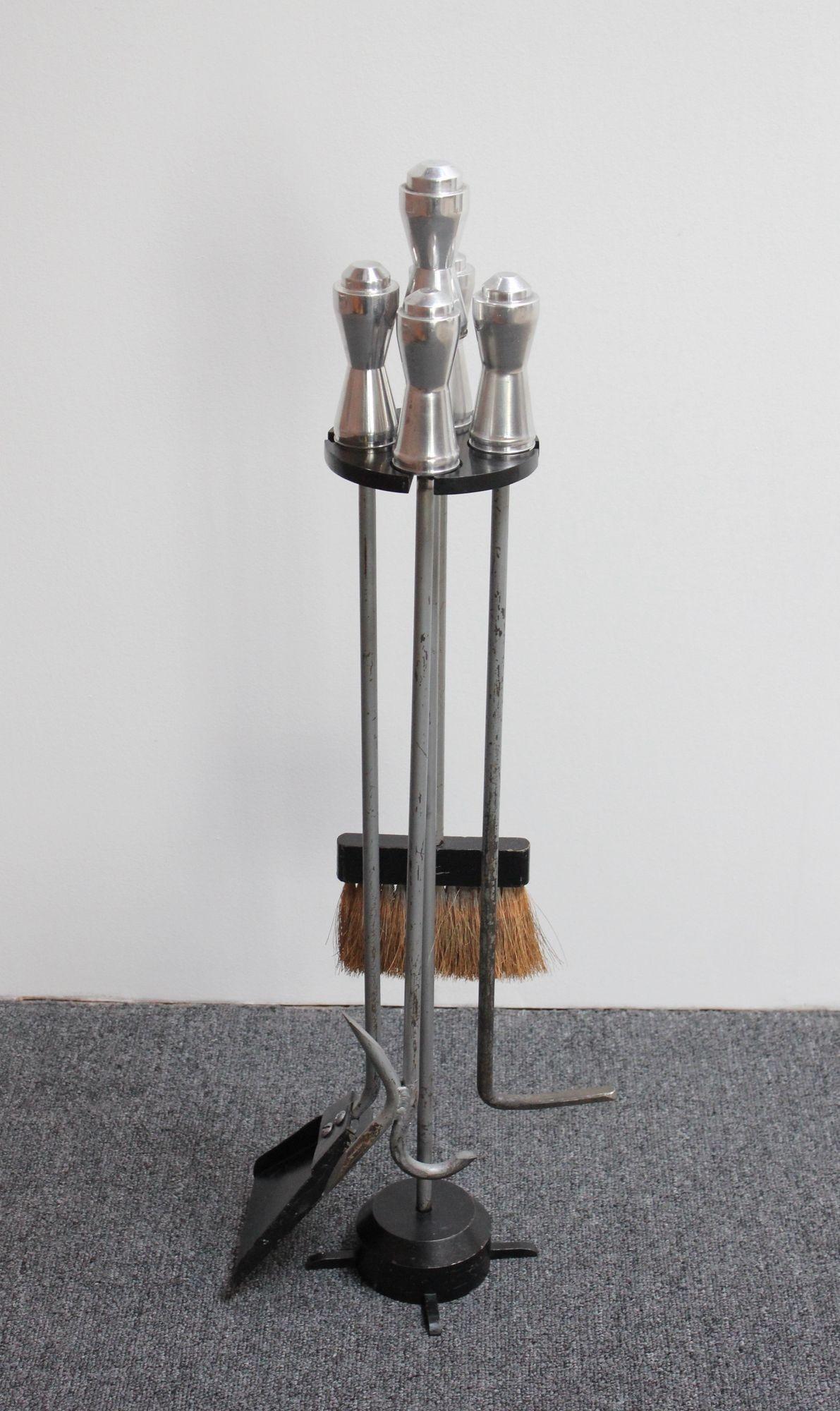 Vierteiliges Vintage-Feuerwerkzeugset mit Schaufel, Bürste, Schürhaken und Blasrohr (ca. 1940er Jahre, USA).
Der Ständer besteht aus einem schwarzen beschwerten Stahlsockel und einem Bakelit-Halter. Alle Griffe (Ständer und Werkzeuge) sind aus