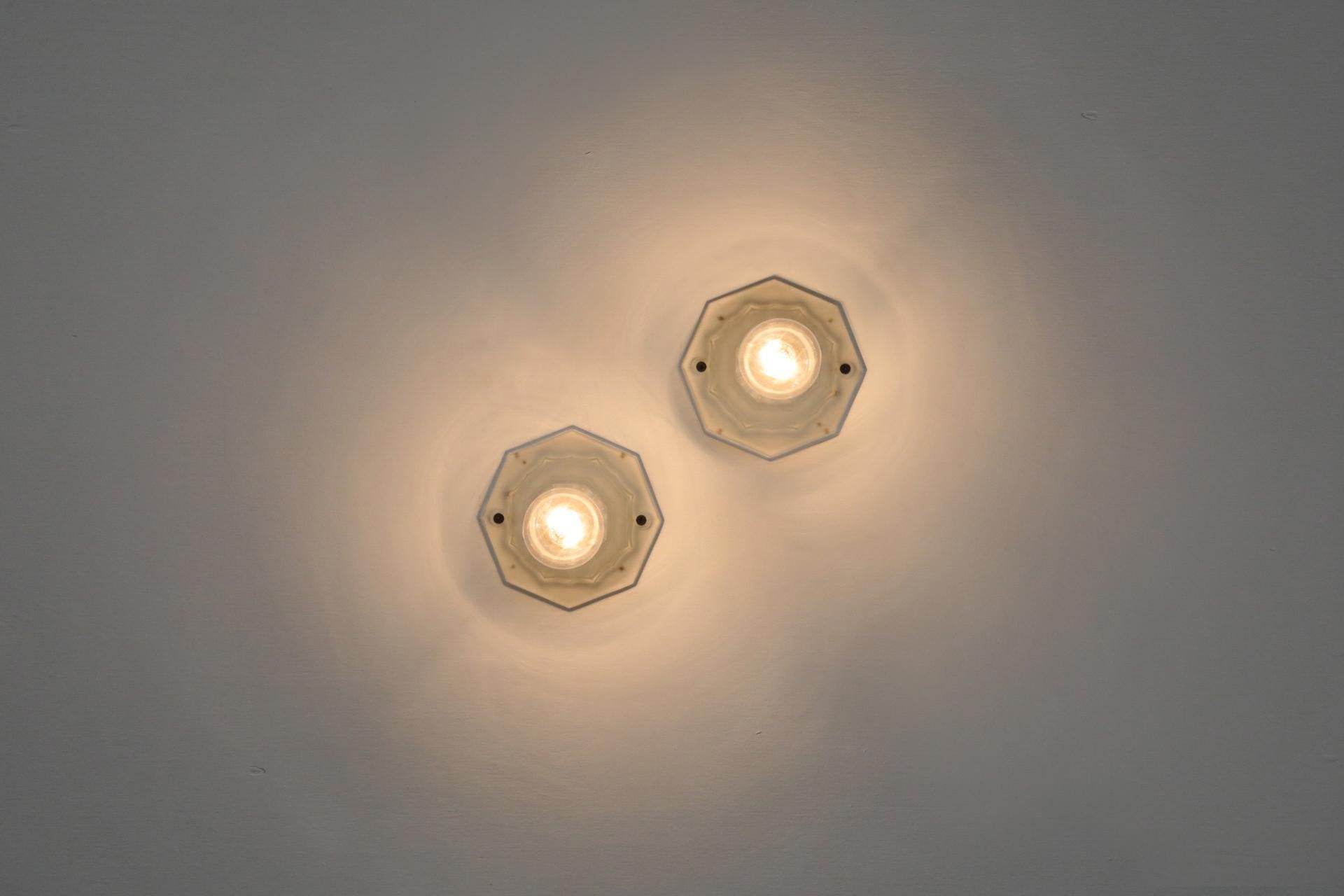 Graziosi portaprese da parete o da soffitto in vetro fuso Art&Deco. Il vetro ornato presenta alcuni segni di usura e graffi, dovuti al normale utilizzo. L'usura è coerente con l'età e l'uso. Una piccola scheggiatura su uno dei fori di montaggio.