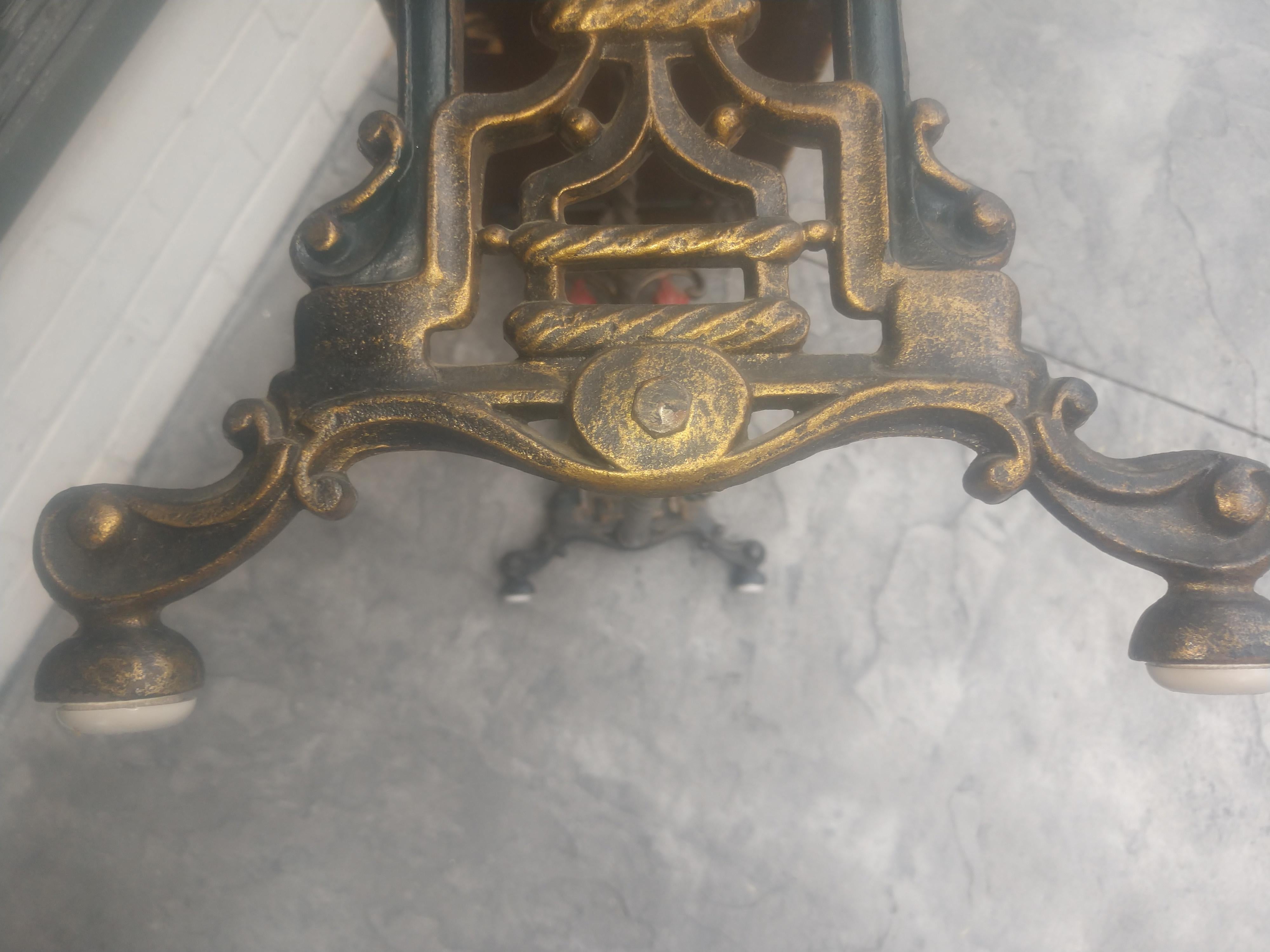Cast iron bench with faces cast in the iron and all original paint and fabric. Fabric is serviceable and a little dated an easy update. In excellent vintage condition with almost no wear.