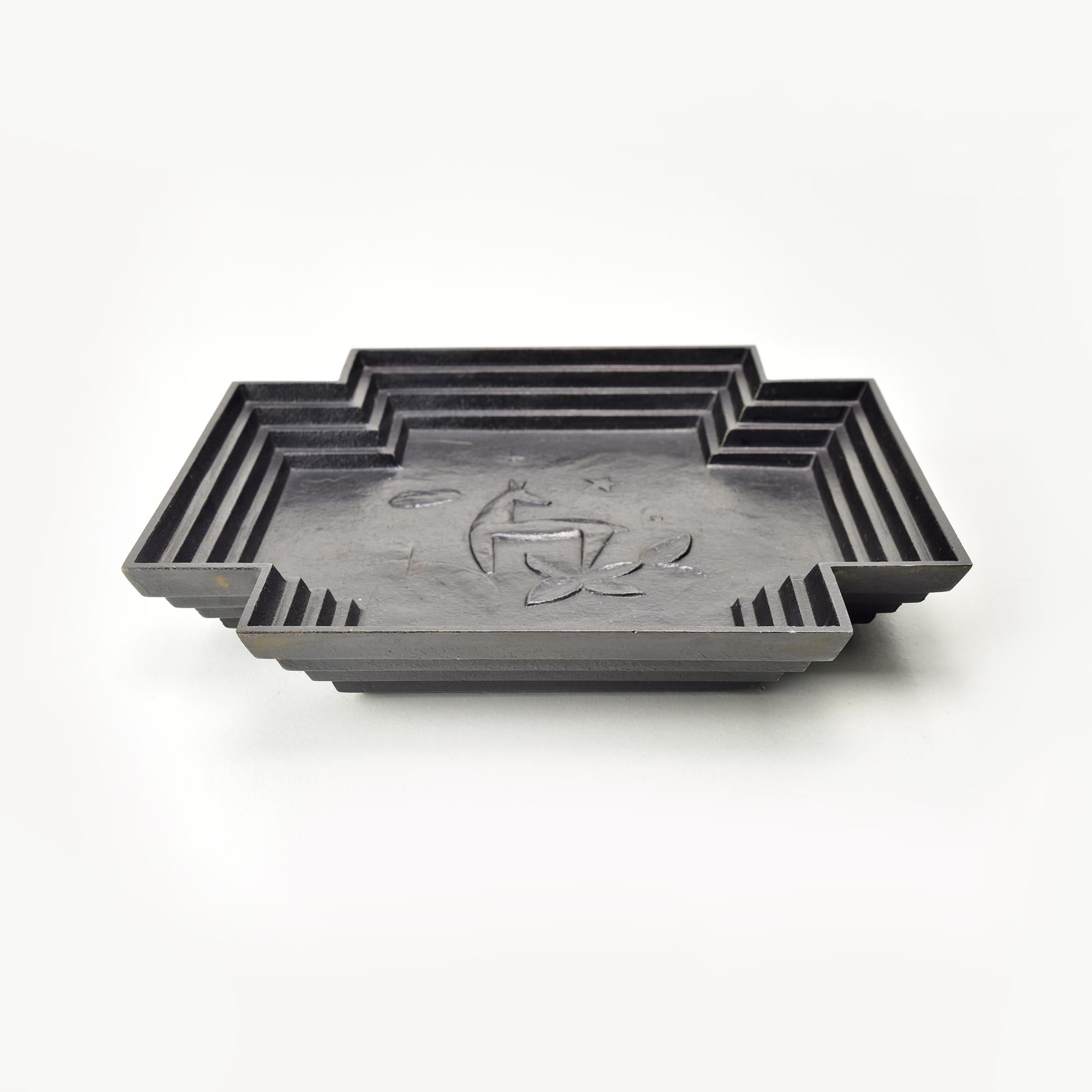 This striking Art Deco cast iron jewelry bowl od vide poche, attributed to Ivar Johnsson for Näfveqvarns Bruk, epitomizes 1920s Scandinavian design. 
The piece showcases geometric stepped edges and a refined embossed central motif depicting a deer