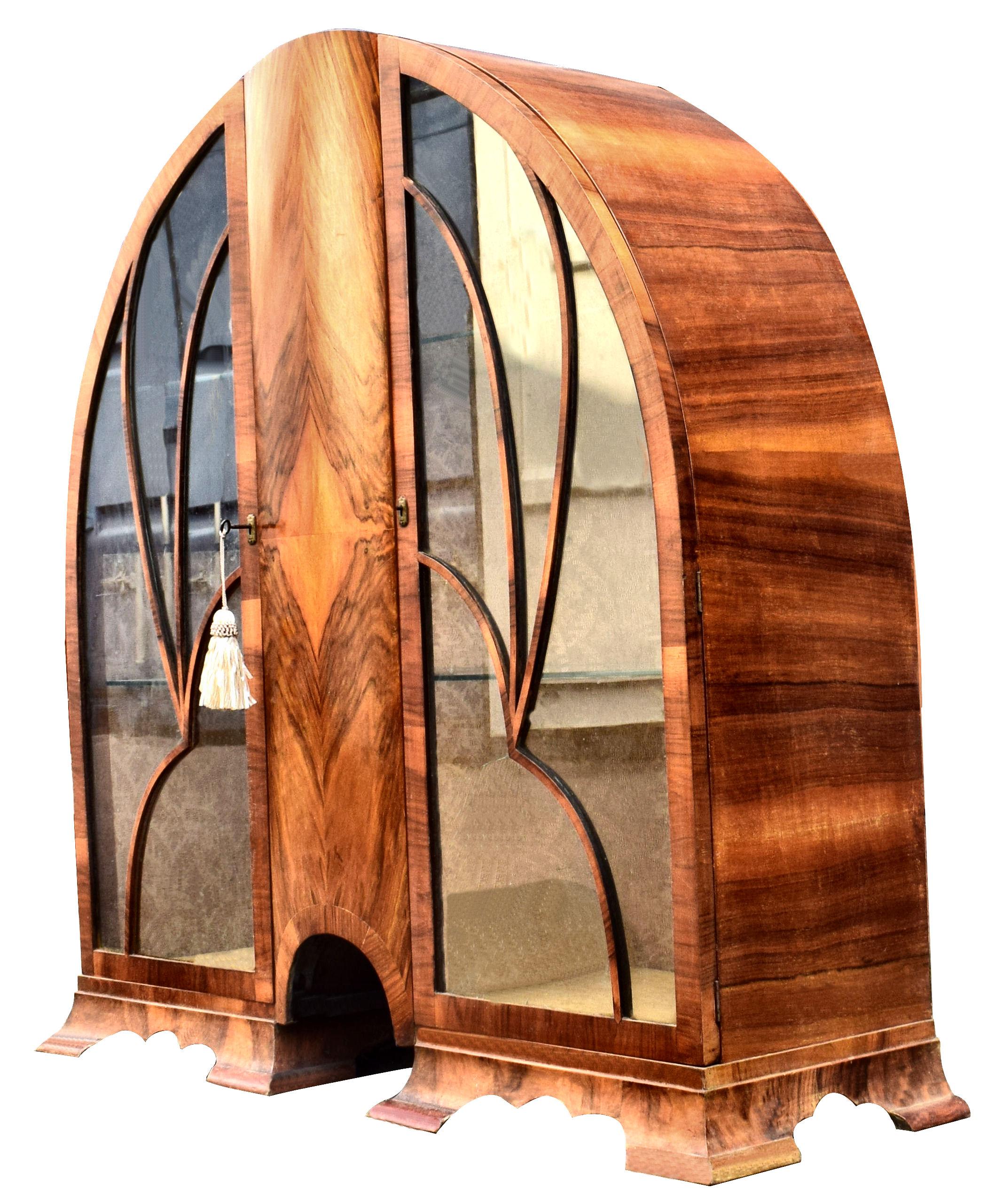 Superb 1930s Art Deco walnut cathedral display cabinet. Gorgeous mid to light tone walnut veneers, still with original working key and two glass shelves. Generously spaced interior, still with its original silk lined backing which is a champagne