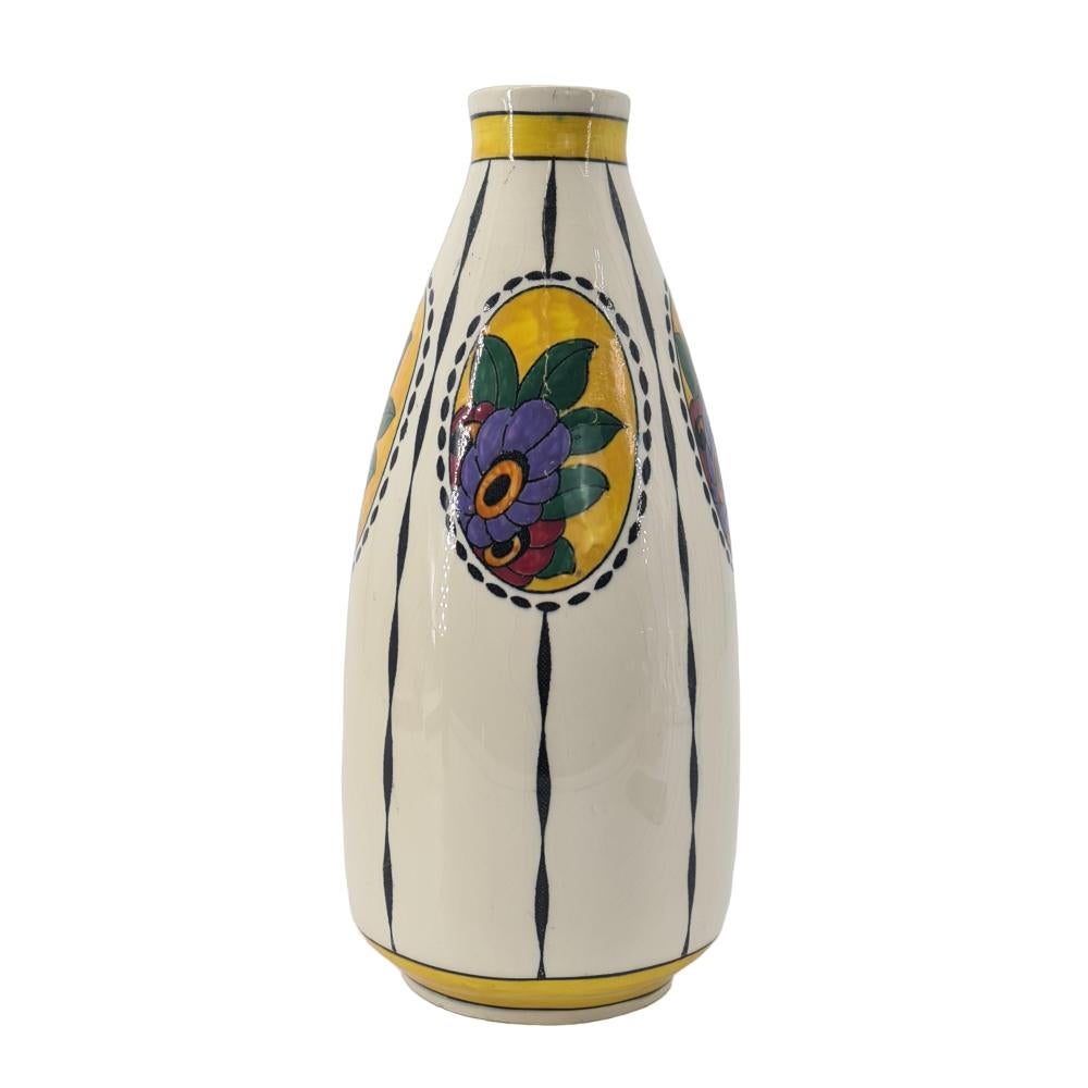 Vase ART DECO CATTEAU Charles pour Boch Keramis F781 1923.
Avec des médaillons ovales sur l'épaule, chacun décoré de trois fleurs simplifiées et de cinq feuilles simplifiées et avec un contour composé de petits ovales. Le vase est divisé par de
