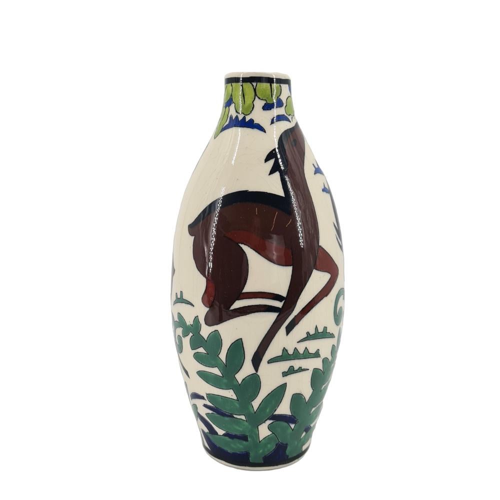 Vase ART DECO CATTEAU Charles pour Boch Keramis 1930.
Le corps est décoré de trois figures simplifiées dans des poses différentes, dans un paysage de plantes stylisées. Ligne noire à la base du cou.

Matière : Creamware
Technique:Forme de moulage