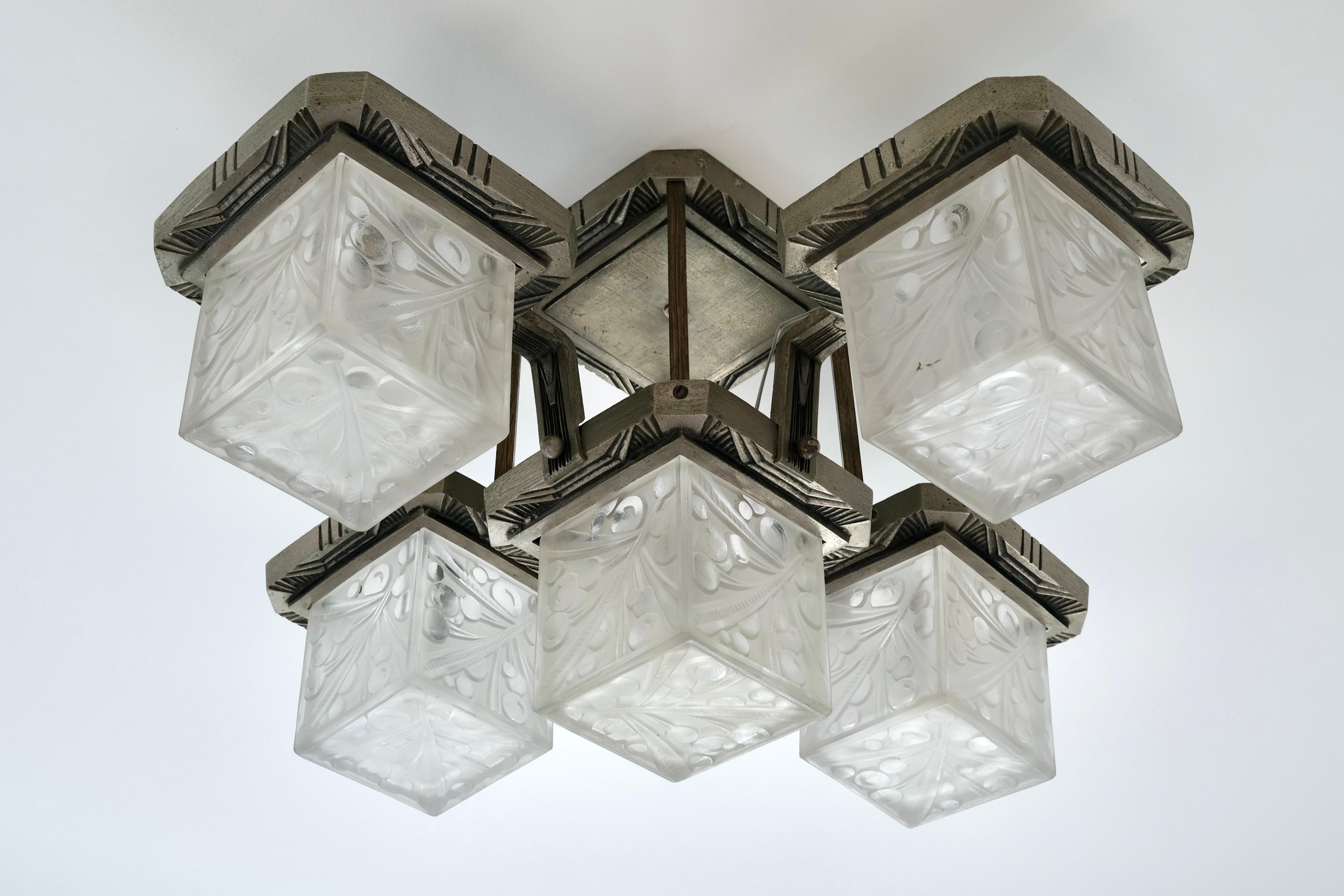 Questa squisita lampada da soffitto Art Déco degli anni '20 porta a casa tua un pezzo di design francese senza tempo. Caratterizzata da una montatura originale in bronzo con una patina ricca e intatta, questa lampada racchiude la bellezza