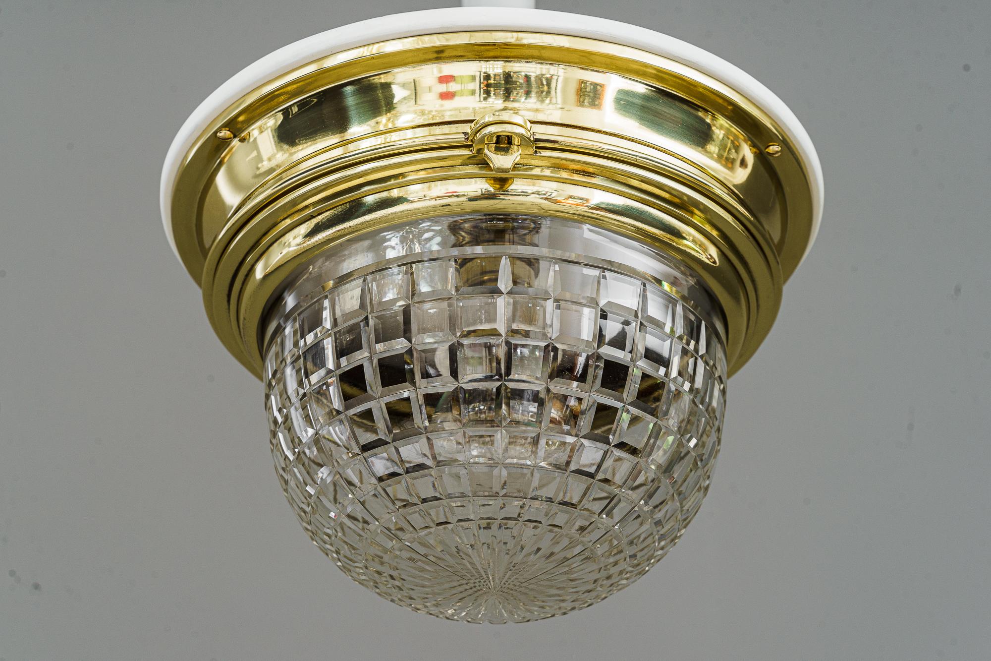 Deckenleuchte im Art déco-Stil mit geschliffenem Glasschirm Vienna aus den 1920er Jahren 
Der Glasschirm kann zum Auswechseln der Glühbirne geöffnet werden
Polierte und einbrennlackierte Messingteile
Weiße Holzplatte auf der Oberseite