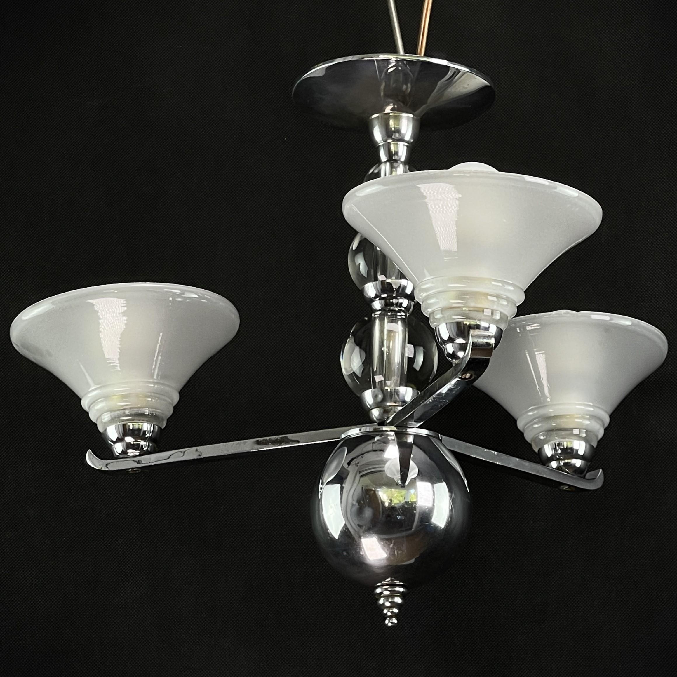 Art Deco ceiling lamp - 1920s

An art deco chandelier in the style of 1920s could have an impressive and elegant design. It is made of glass balls and chrome elements that capture the characteristic glitz and glamor of that time.
The combination