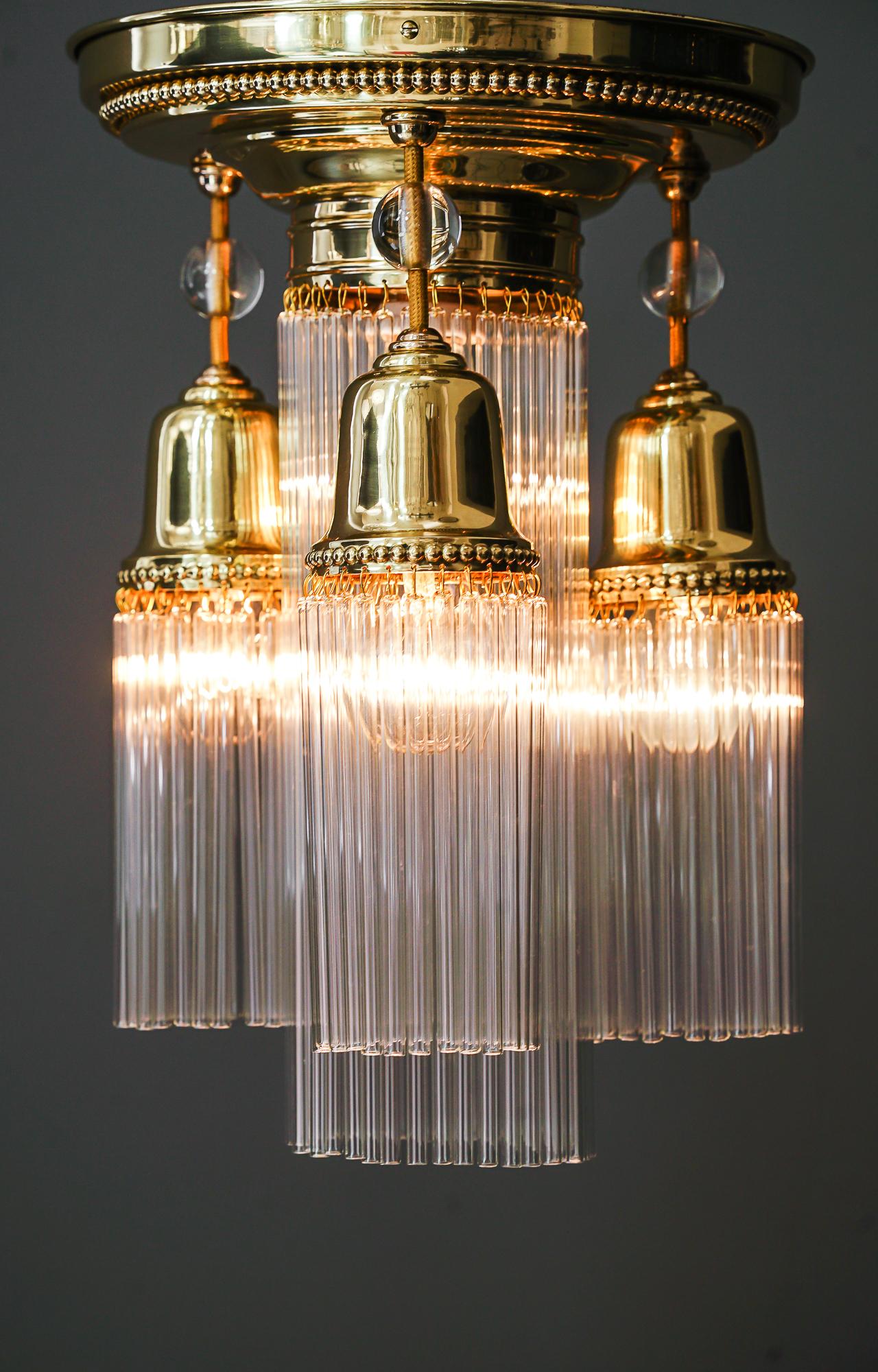 Art Deco ceiling lamp with glass sticks, Vienna, around 1920s.
Brass polished and stove enameled.
The glass sticks are replaced (new).