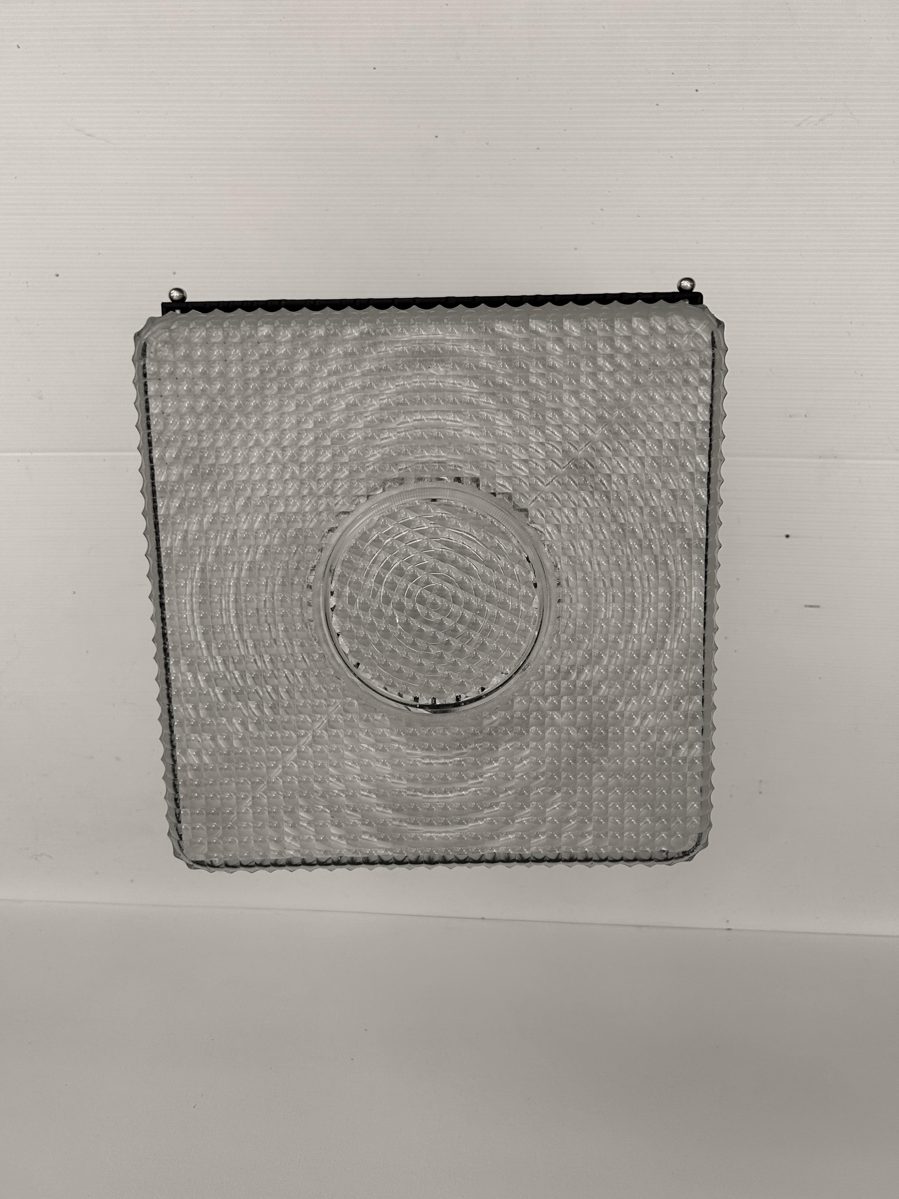 Plafoniera Art déco del 1935 circa. 
 Vetro stampato firmato Holophane n° 2511. 
 Telaio in ferro martellato. 
 2 luci, presa E14. 
 In perfette condizioni. 
 
 Altezza: 13.5 cm 
 Larghezza: 29 cm 
 Lunghezza: 29 cm 
 Peso: 5 Kg 
 
 La storia