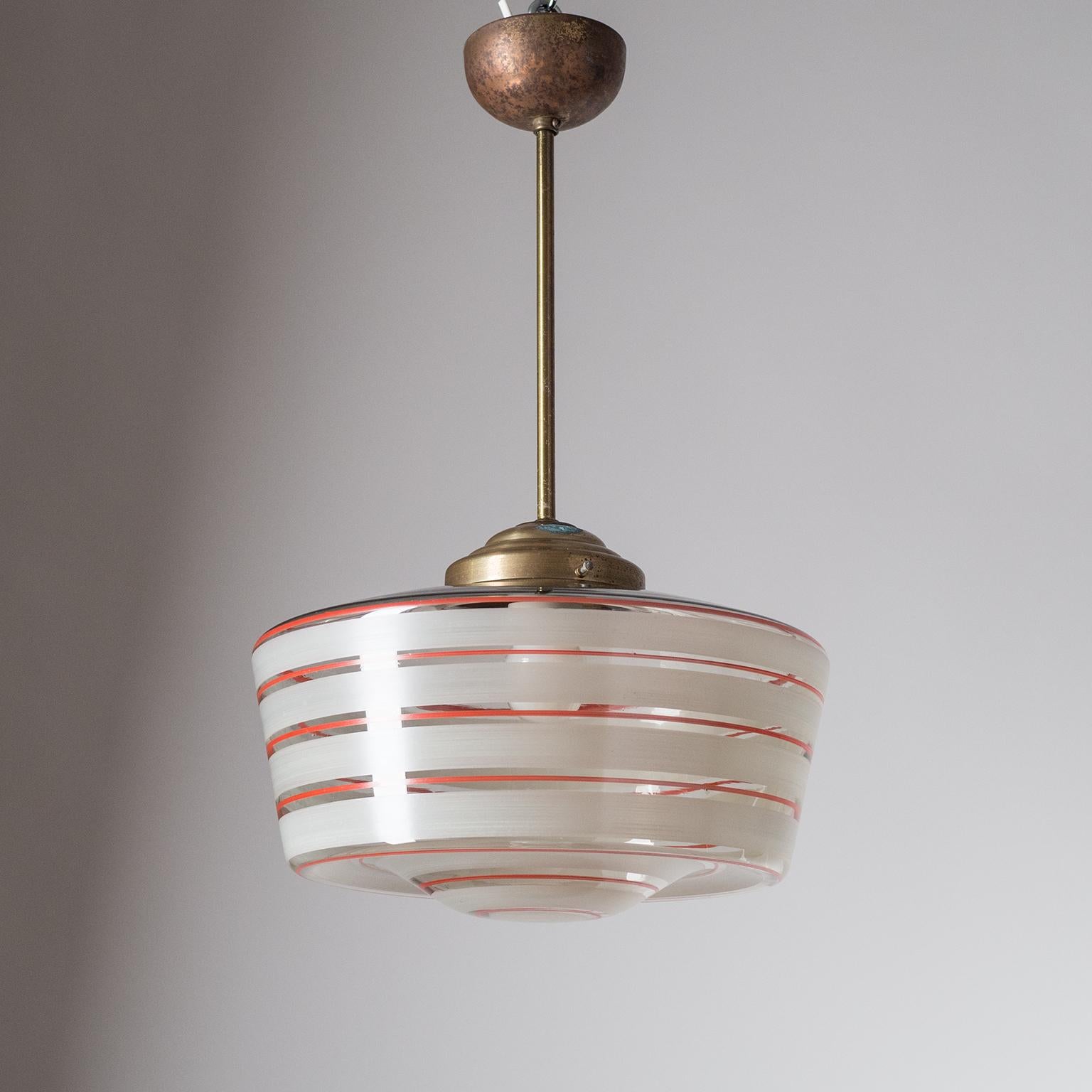 Rare hand painted glass Art Deco pendant, circa 1930. The large blown glass diffuser is enameled with off-white and red stripes which were applied by hand, the texture and varying thickness of brush strokes visible. The hardware is made of brass