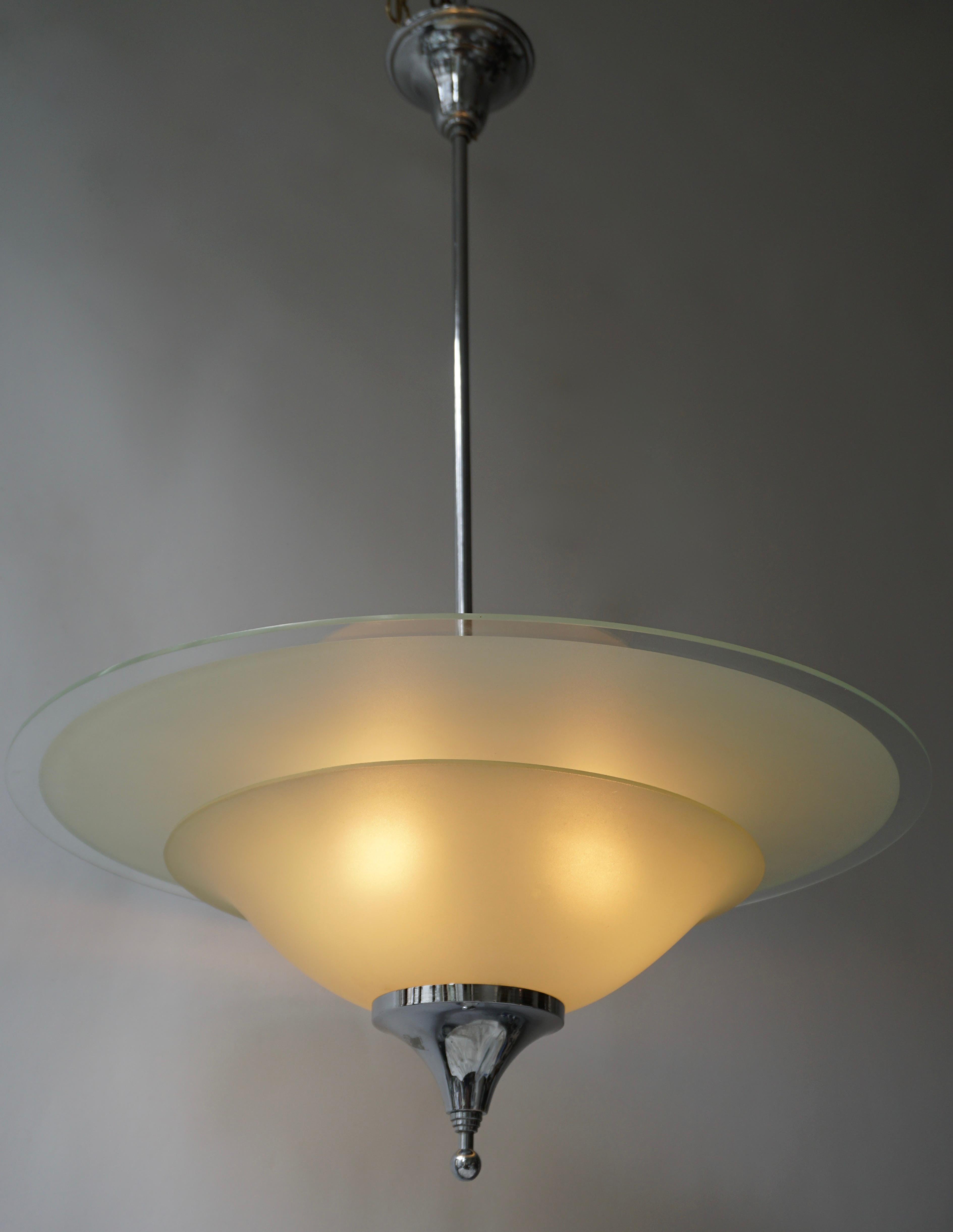 Merveilleuse lampe à suspension décorative en chrome et verre dépoli, conçue et fabriquée en Belgique dans les années 1930. 
Le lustre est entièrement fonctionnel et en très bon état vintage.

Le luminaire nécessite trois ampoules simples à vis