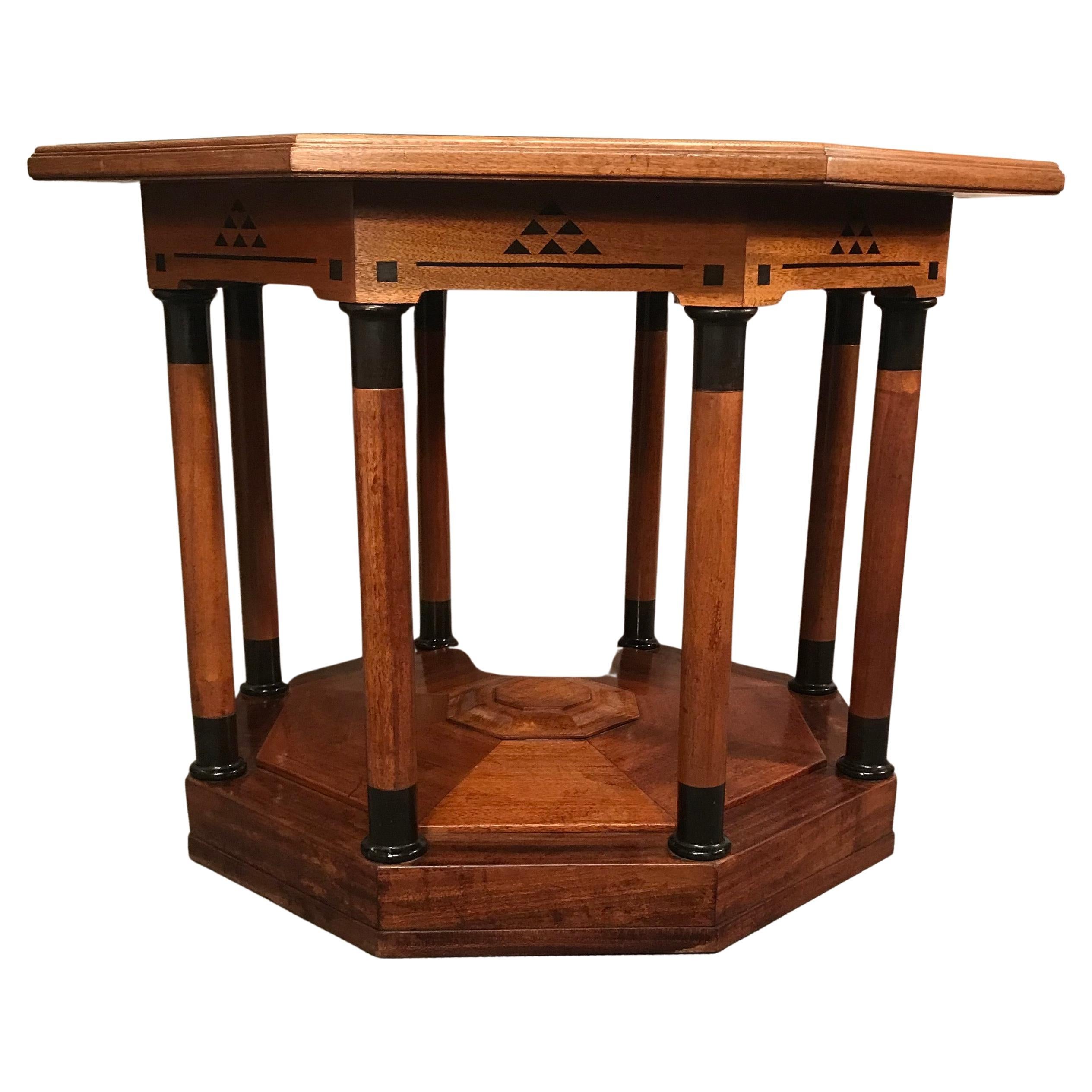 Dieser einzigartige Art-Déco-Tisch stammt aus der Zeit um 1910-20. Es kommt aus Deutschland. Der Tisch hat ein Nussbaumfurnier und ist mit geometrischen ebonisierten Intarsien aus verschiedenen Holzarten verziert. Er hat einen achteckigen Aufsatz