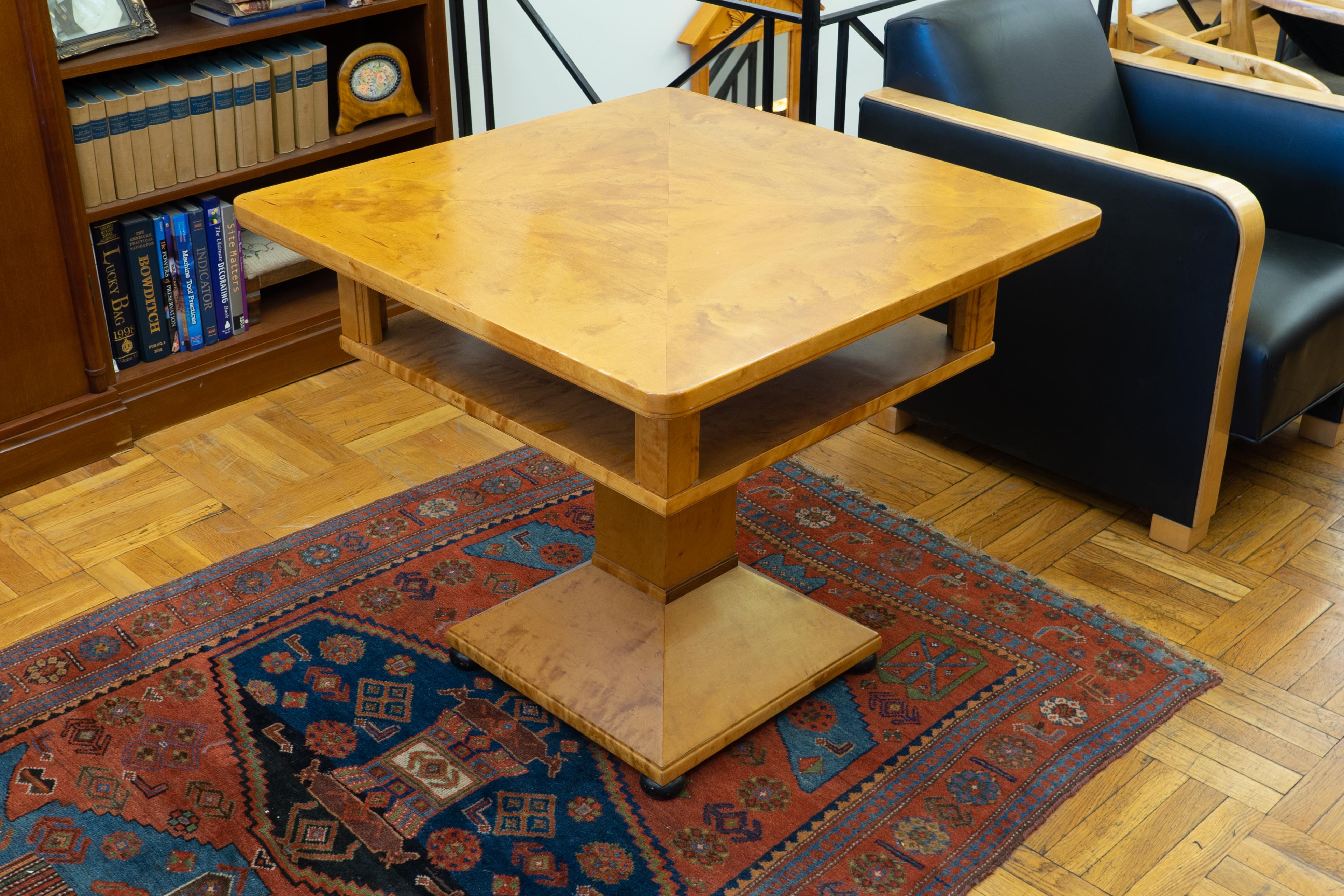 Nordic birch veneer adorns this center table. An open compartment supported by architectural columns is fully finished as well and is meant to allow light to pass through the space. A pyramidal base with a footprint of 19” x 19” completes the design