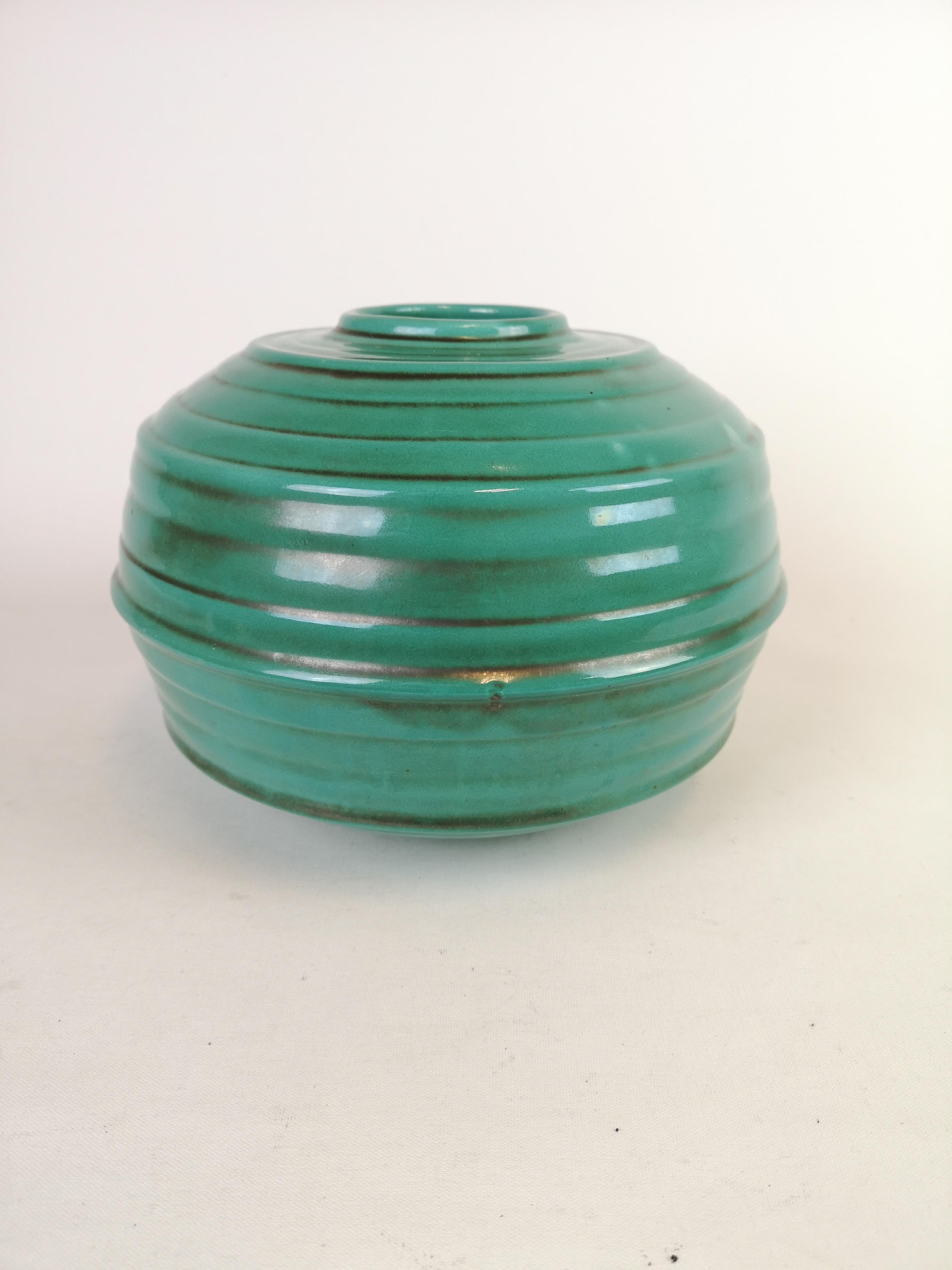 This wonderful bowl was manufactured at Ekeby in Sweden 1930, 1940s
It has a very nice green blue glaze, and its shape is in Art Deco style.  

Nice condition, with one small glaze scrape. 

Measures: H 19 cm D 25 cm.
 