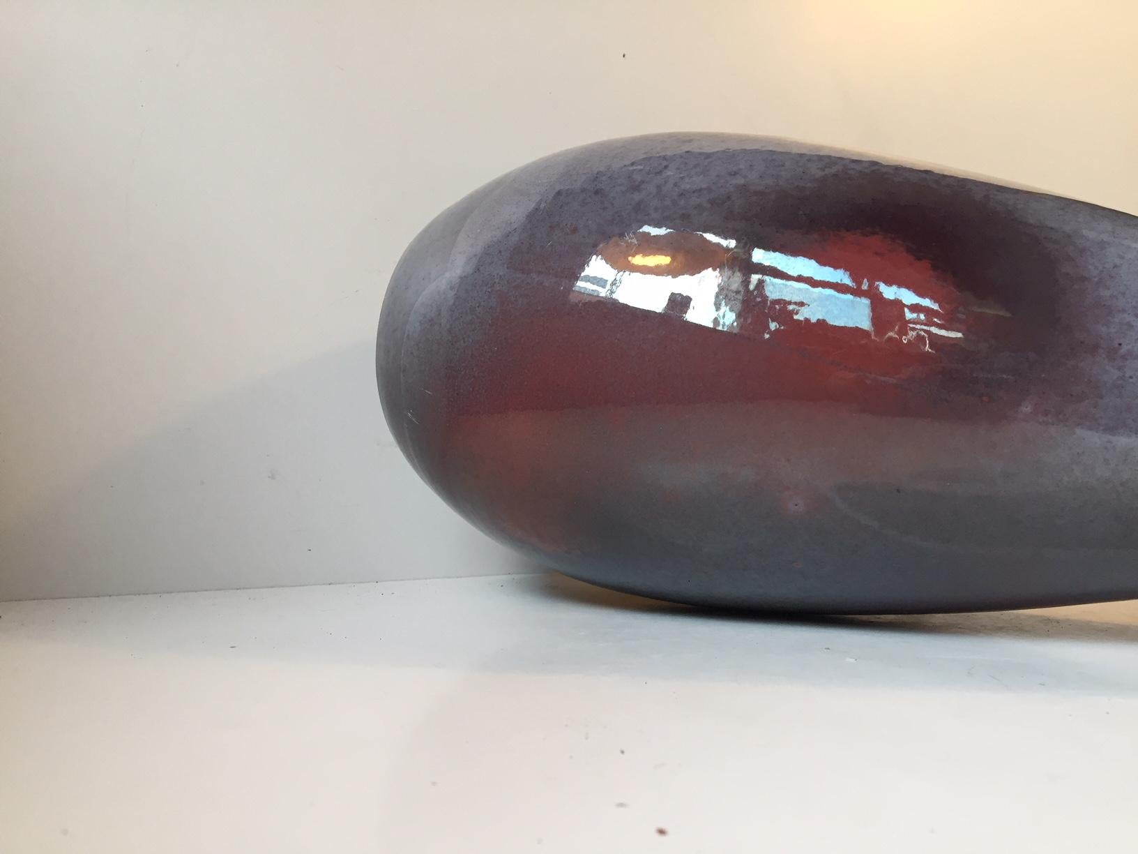Grand vase unique dans un vibrant mélange de glaçures au sang de boeuf. Elle a été réalisée par un céramiste danois appelé Øbo qui a travaillé pendant un certain temps chez Michael Andersen & Son sur l'île de Bornholm dans les années 1930. Cette