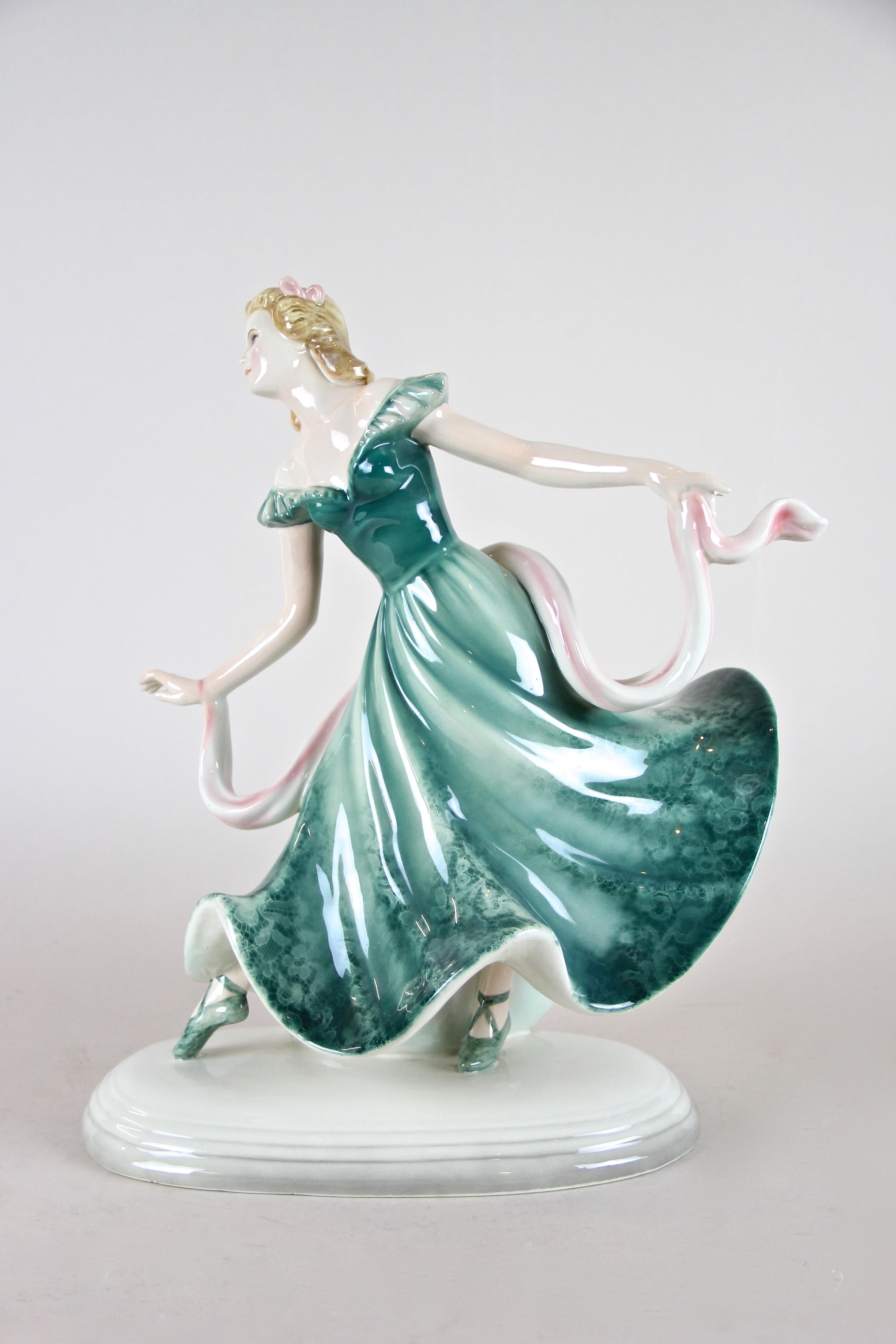Charming Art Deco Ballerina ceramic sculpture made by Keramos Vienna, Austria, circa 1925. This lovely ceramic sculpture depicts a pretty ballerina in a rare version with a very fine, out of the ordinary painted green dress, holding a white/pink
