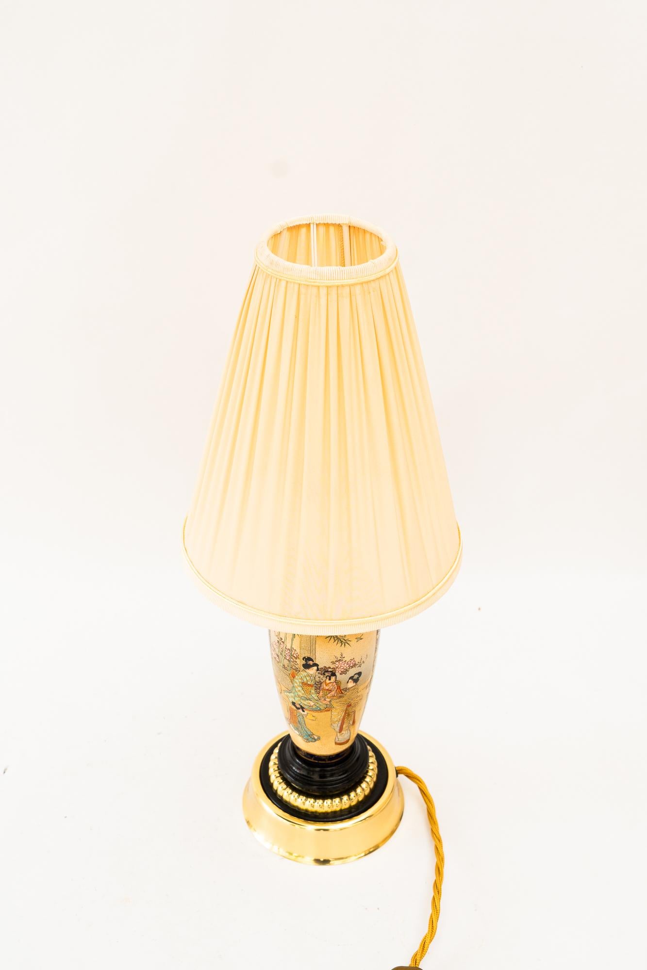 Art Deco ceramic table lamp with fabric shade vienna around 1920s
Brass parts polished and stove enameled
ceramic original condition
The shade is replaced ( new )
