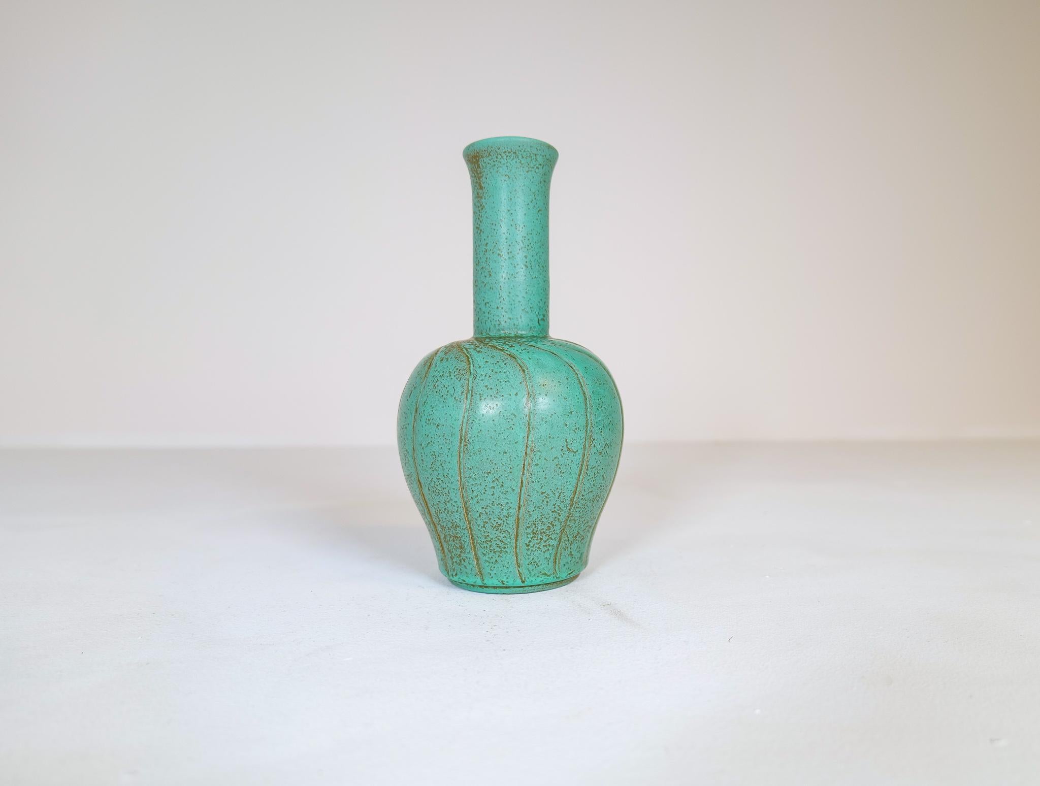 Merveilleux vase en céramique fabriqué en Suède à Bo Fajans et conçu par Ewald Dahlskog 1937.
La forme et les lignes du vase se marient parfaitement avec la merveilleuse glaçure. Les tourbillons de vert plus foncé se marient parfaitement avec le