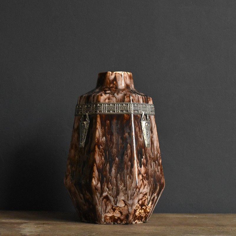 Belgian pottery vase with silvered bronze decoration

Enamelled, almost tortoiseshell decoration on earthenware.

Applied geometric metalwork in the Art Deco fashion.

A handsome and highly decorative piece by an acclaimed French