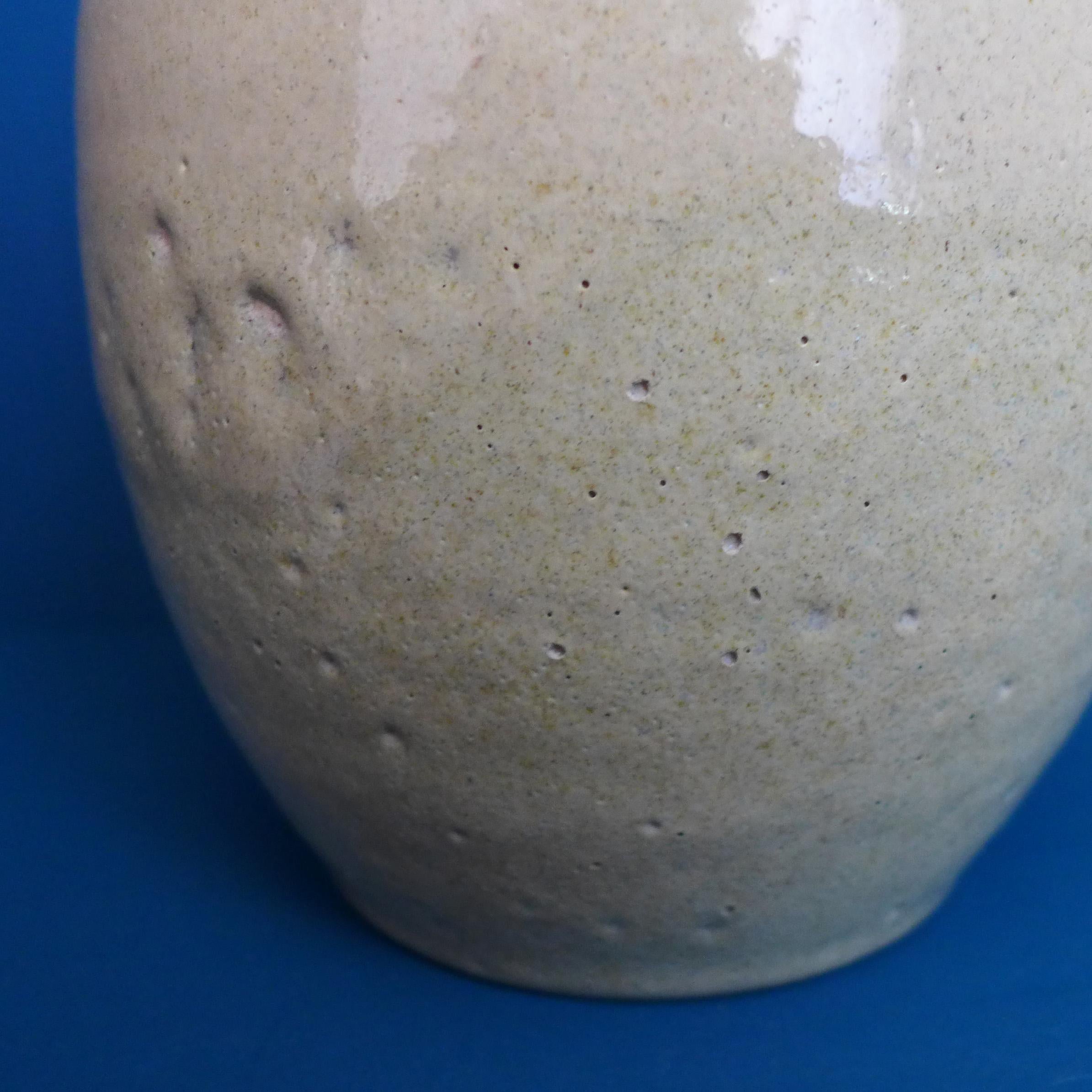 A piece of Dutch pottery history in the form of this beautifully glazed vase by Chris Lanooy, (1881-1948). High gloss sand colored glaze with a pitted texture. The lower part of the vase has a slight moss-colored underglaze.

Signed: C J Lanooy.