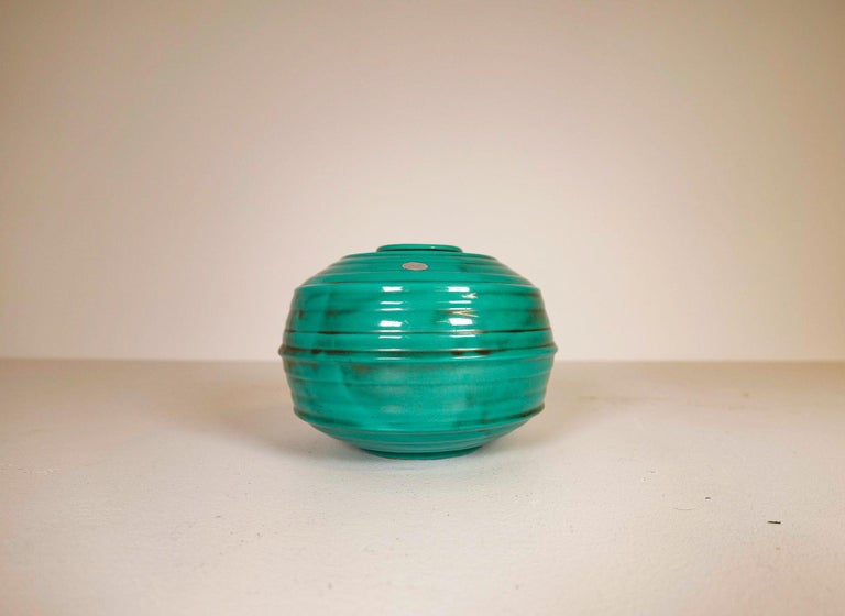 This wonderful bowl was manufactured at Ekeby in Sweden 1930, 1940s
It has a very nice green blue glaze, and its shape is in typical Art Deco style.  

Nice condition, with one small glaze scrape. 

Measures: H 19 cm D 25 cm.
 