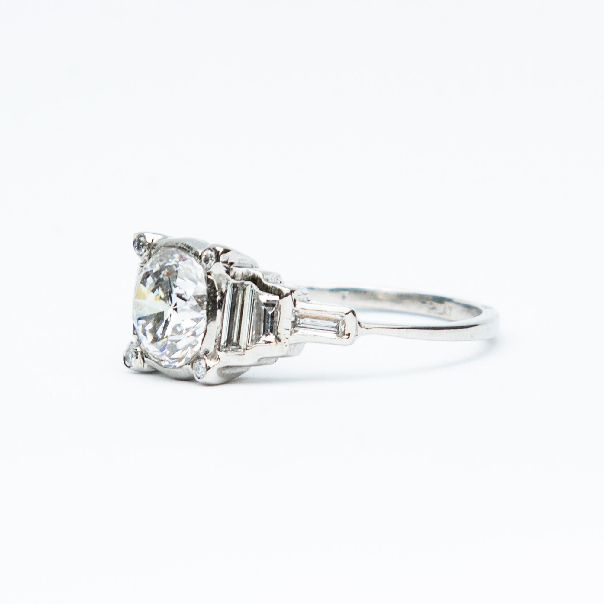 This a perfect example of a stunning Art Deco solitaire platinum and diamond ring. The central cushion cut Diamond measures one carat twenty, beautifully complimented with baguette cut diamond shoulders.
Total diamond weight certified 2.15 carat, G