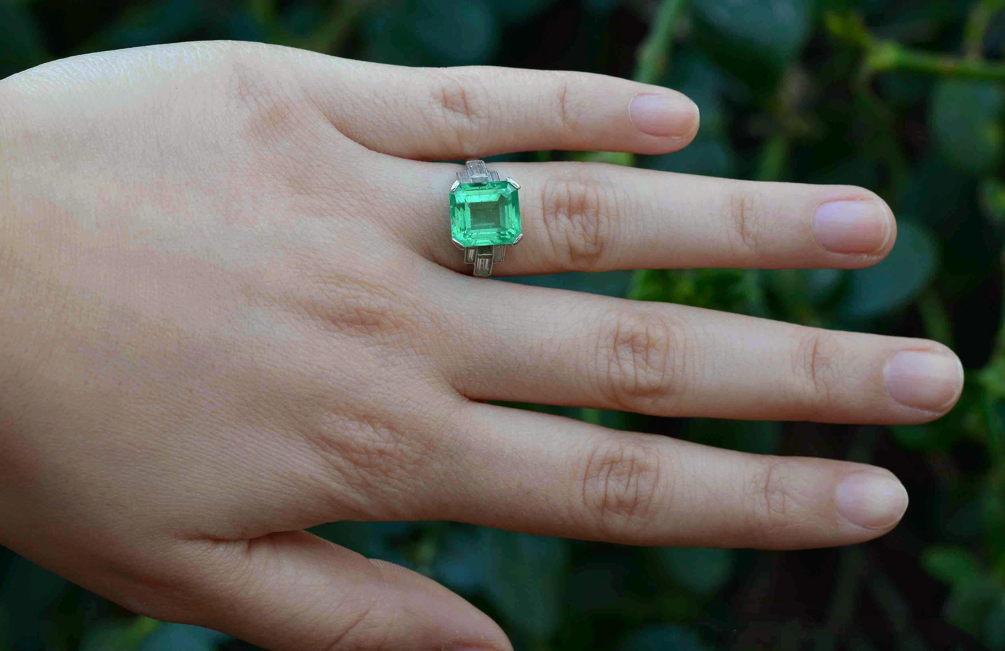 The Palm Springs Art Deco Engagement Ring. Glowing with an inner fire, this spectacular, Certified 5.47 Ct Colombian Emerald is sure to make all jewels green with envy. A classic Emerald cut set in a sleek, minimalist platinum setting enriched by