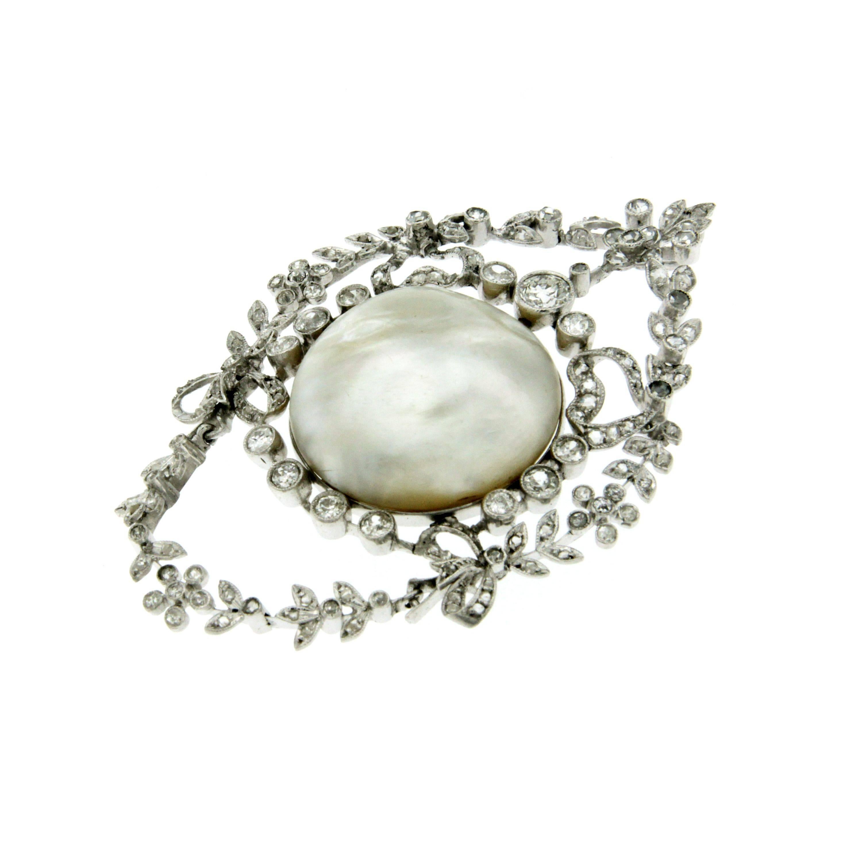 Beautiful and unique 18k white gold pendant, it features in the center a large and sparkling Natural Salt Water Certified Pearl of 28.10 carat in a diamond frame with a laurel wreath, flowers and bows motif.
Diamonds weigh all together approx. 2.50