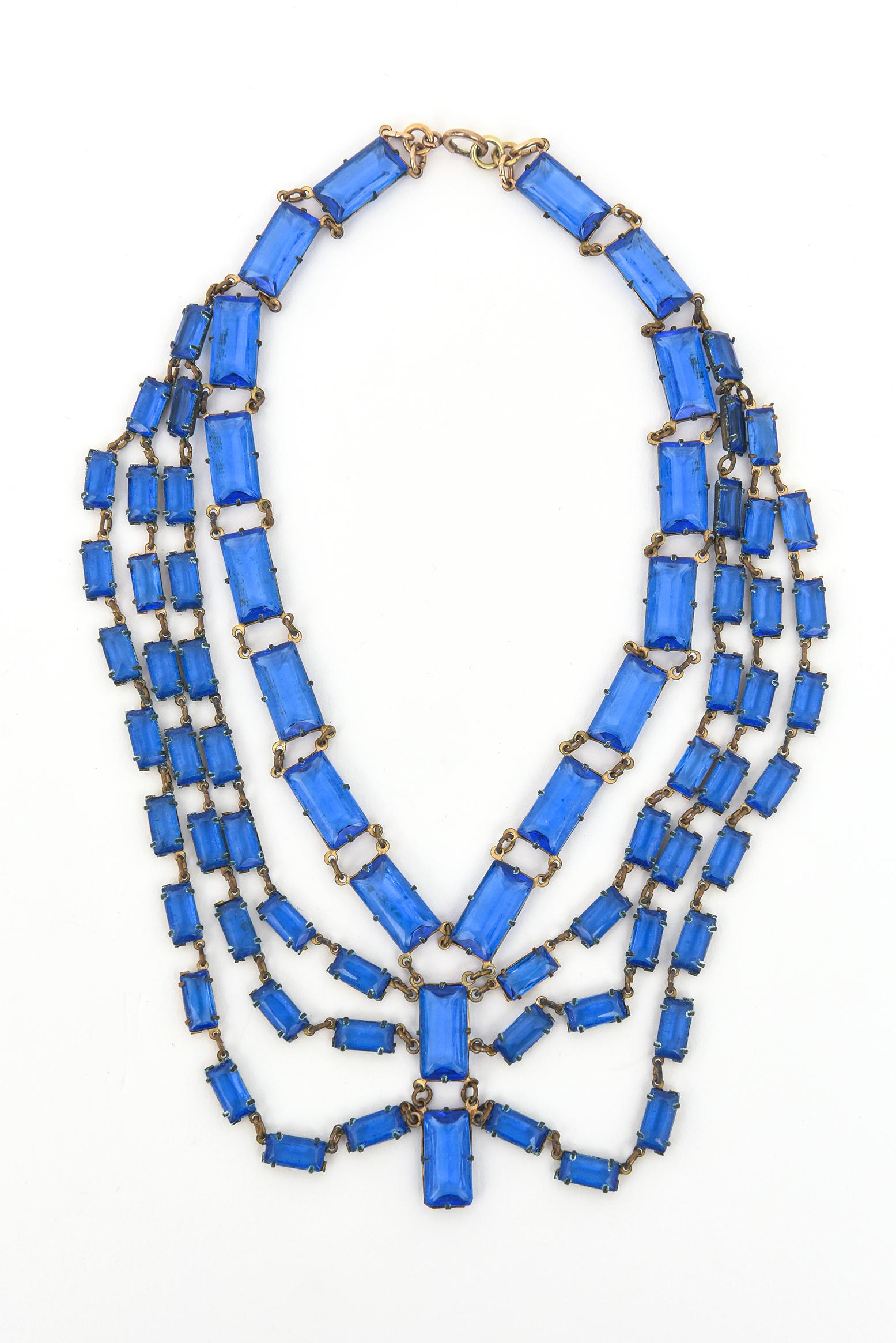 This stunning and elegant vintage original Art deco multi tier and multi strand cerulean blue glass necklace is amazing on the neck. There are 4 graduated rows and a few pendant glass disks hanging. We have had in our archives now for over 35 years