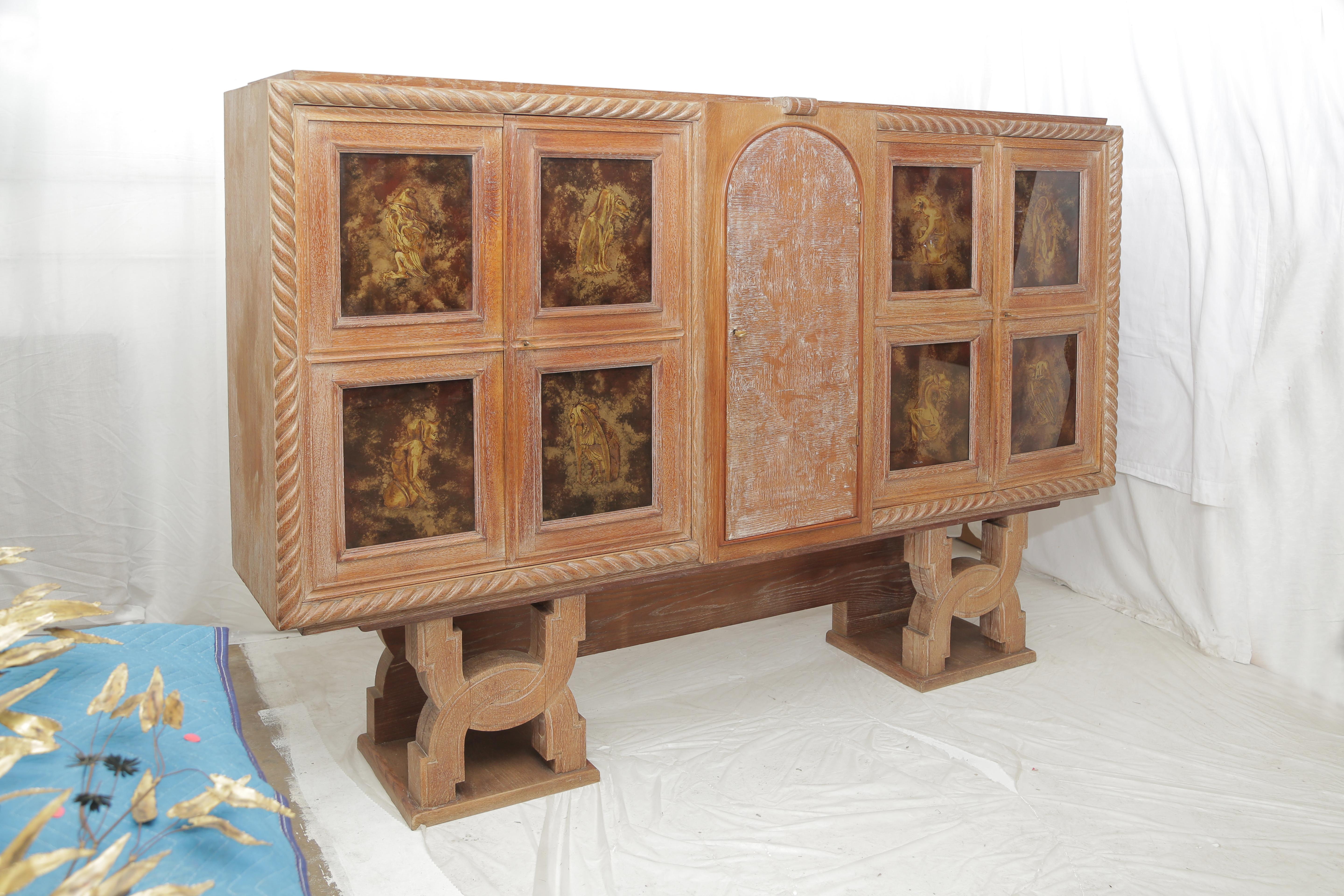 Important cabinet in cerused golden oak .The left inside part of the piece would be more dedicated to be a dry bar. The main part of the piece (47 inches.) stands on a wooden carved base (Height: 20 inches).
Set of drawers in the center part and