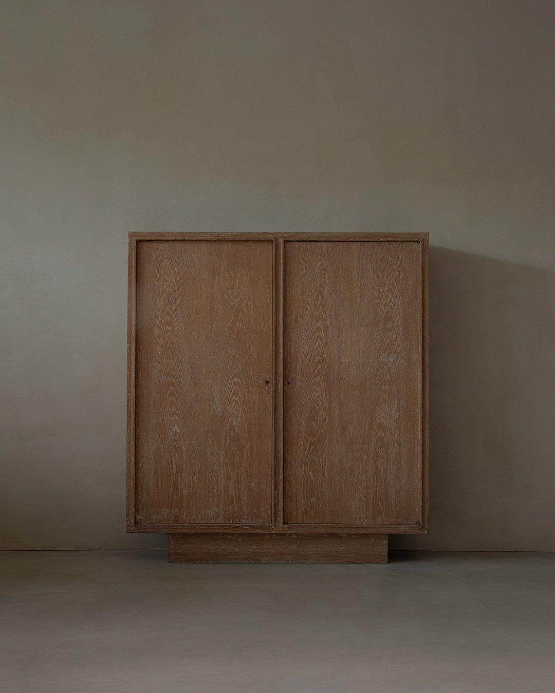 Wardrobe made from cerused oak. This particular finish highlights the wood grain with a subtle whitewashed effect, accenting its texture and natural patterns. Simple, geometric design with clean lines, Art Deco aesthetic typical of the early 20th