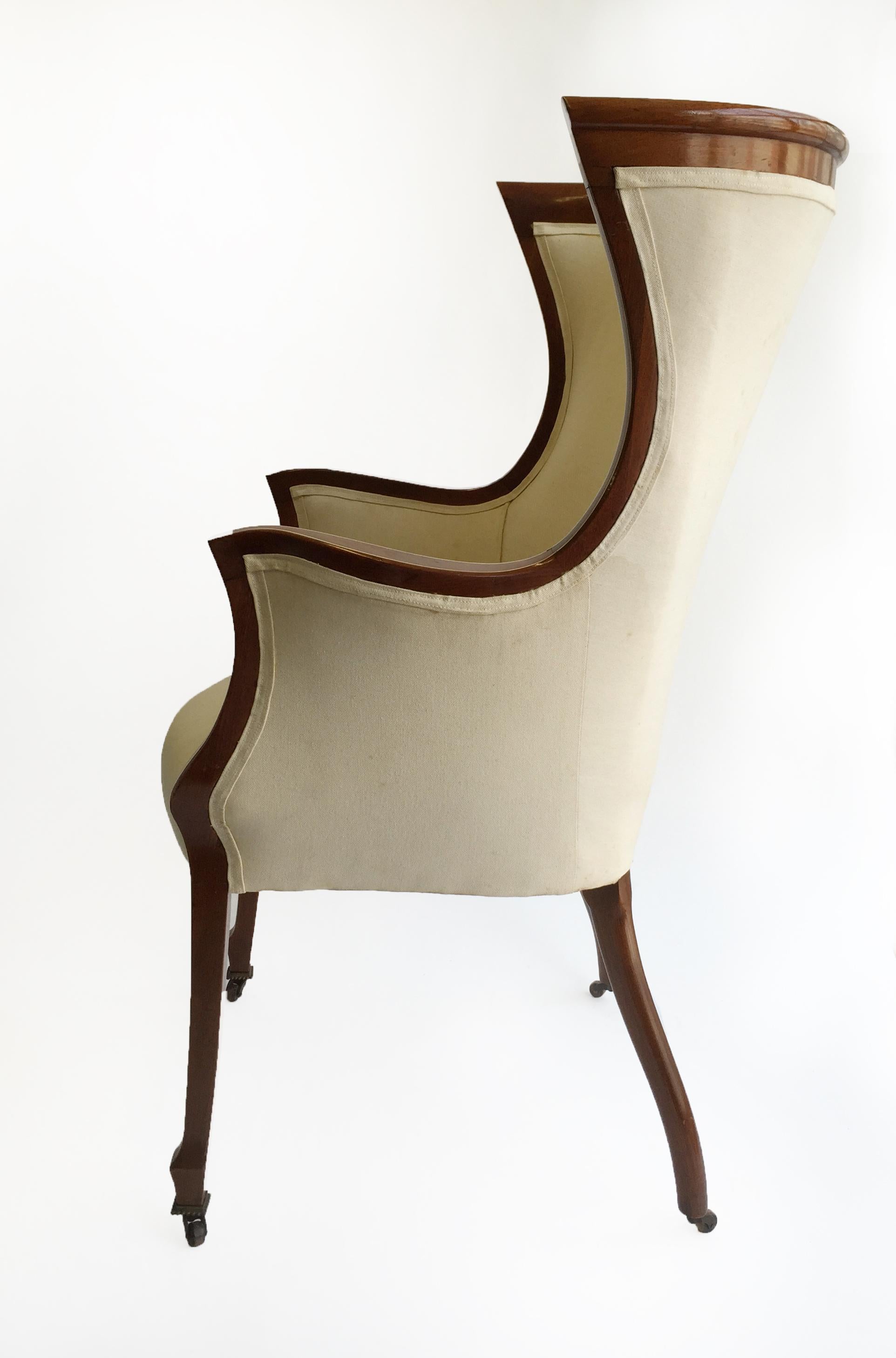 Elegant 1940s Art Deco Wingback chair on casters. The sweeping curves of the chair are highlighted by a subtle wood inlay on the frame, the chair is upholstered in a neutral colored fabric.

Property from esteemed interior designer Juan Montoya.