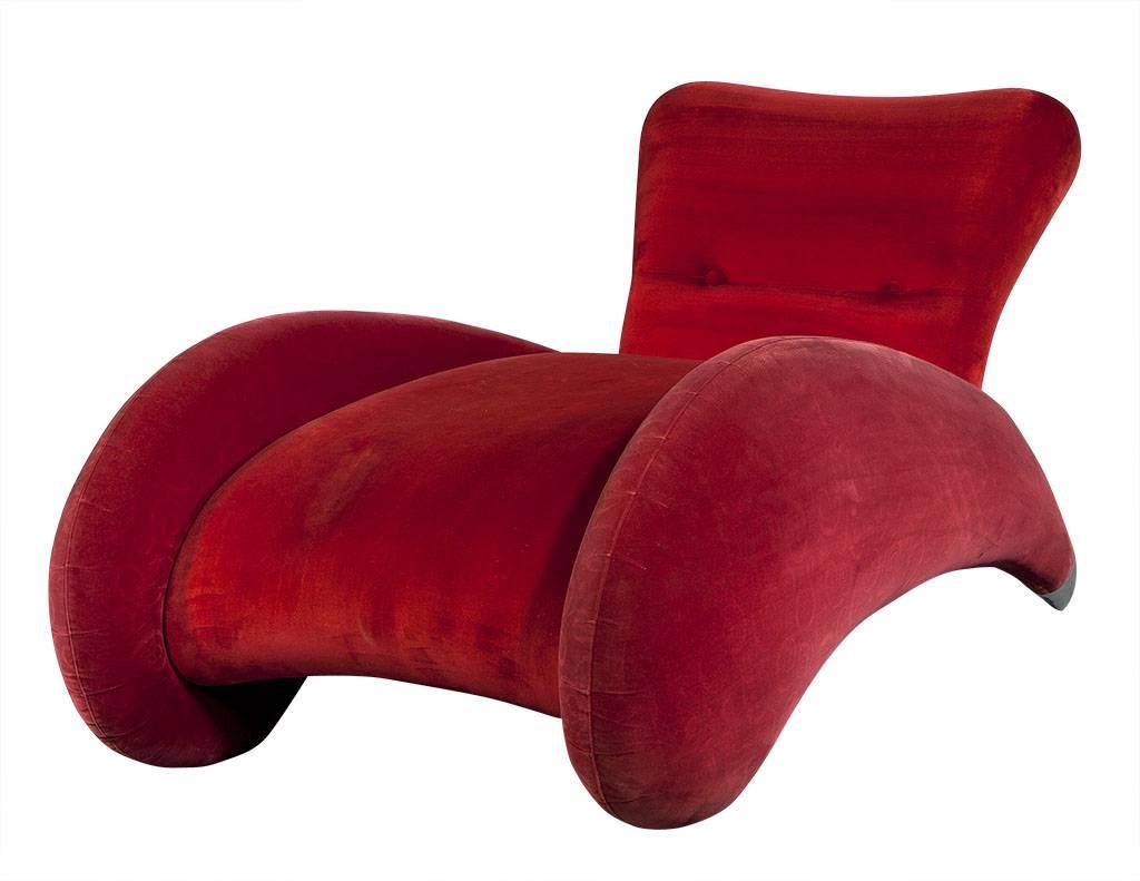 This modern red deco style chaise longue is covered in a red velvet fabric, it sits upon pointed rear feet with large silver metal tips. A truly beautiful and bright piece perfect for a daring home.