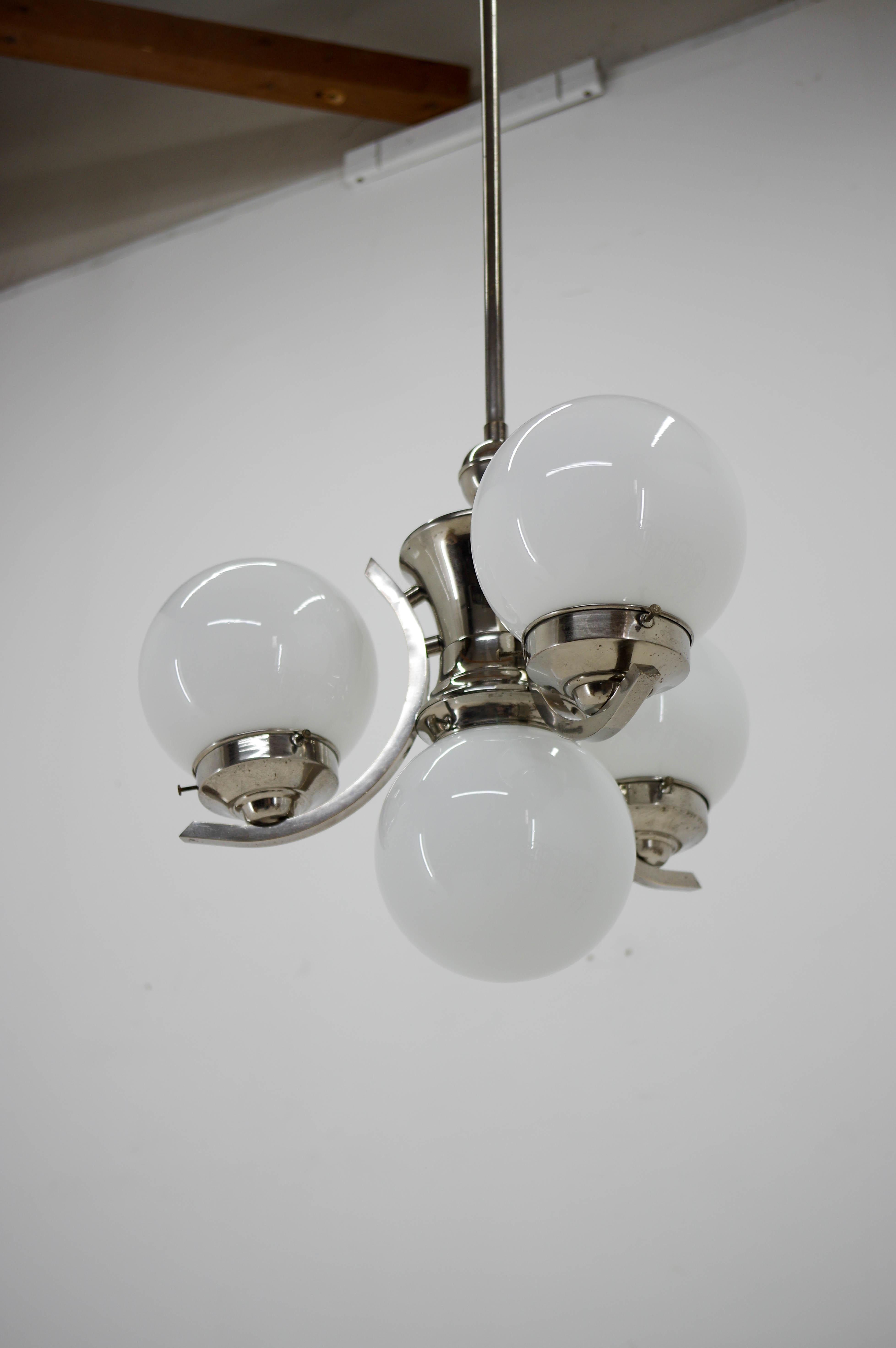 4-flamming Art Deco chandelier with opaline glass shades.
Central rod can be shortened on demand.
One dent on a glass shade not visible when assembled.
Restored: nickel with minimum loses polished, rewired.
Two separate circuits: 1+3x60W, E25-E27