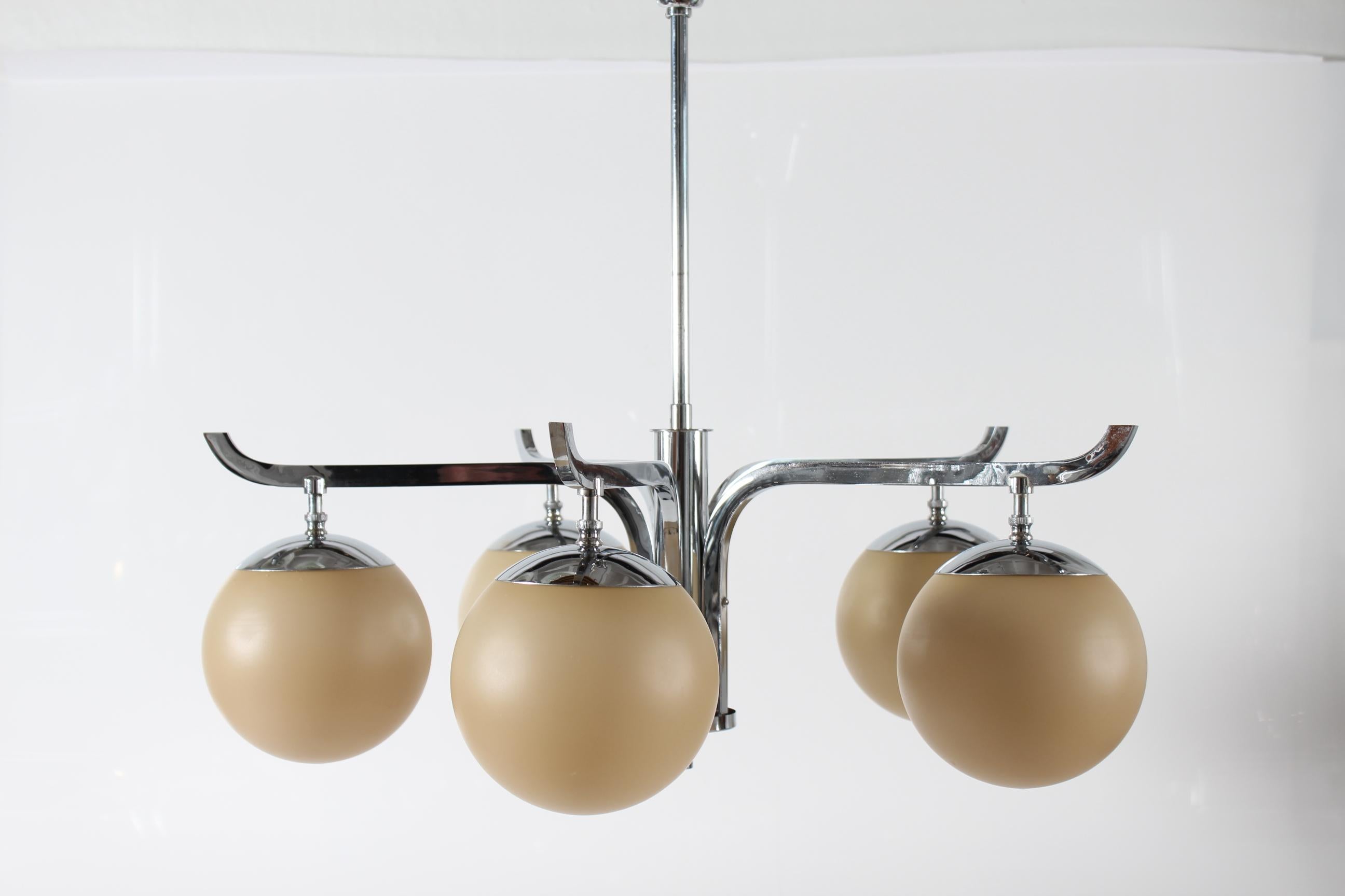 Art Deco 5-armed chandelier manufactured by the Danish Lamp company Fog & Mørup in Copenhagen in the 1930s.
The frame is made of shiny chromium plated metal with five ball shaped shades of  beige color glass.

Stamp in the frame: Fog & Mørup

Height