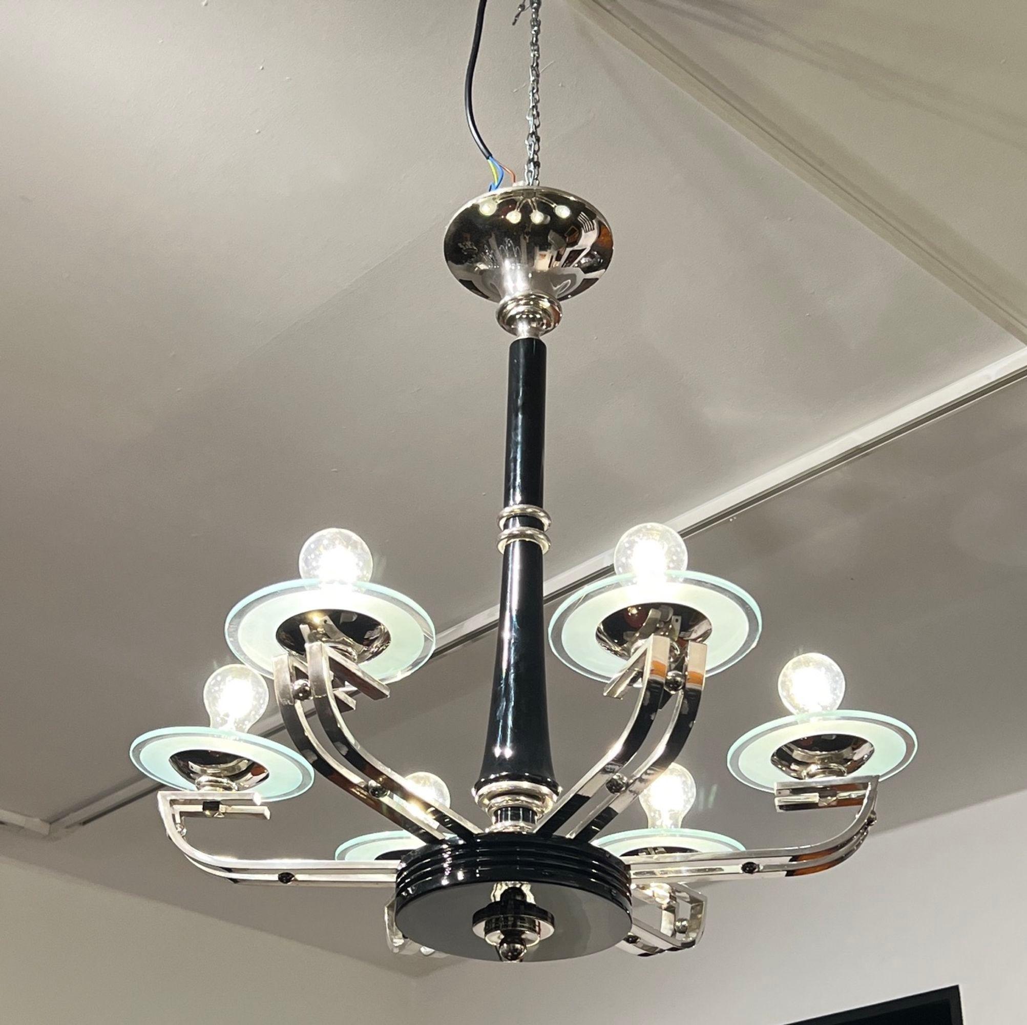 Elegante lampadario o lampada da soffitto a sei luci in stile Art Déco proveniente dalla Francia intorno al 1930.
Colonna in legno laccato nero con parti cromate lucide.
6 sorgenti luminose con lastre di vetro rotonde e parzialmente incise al di