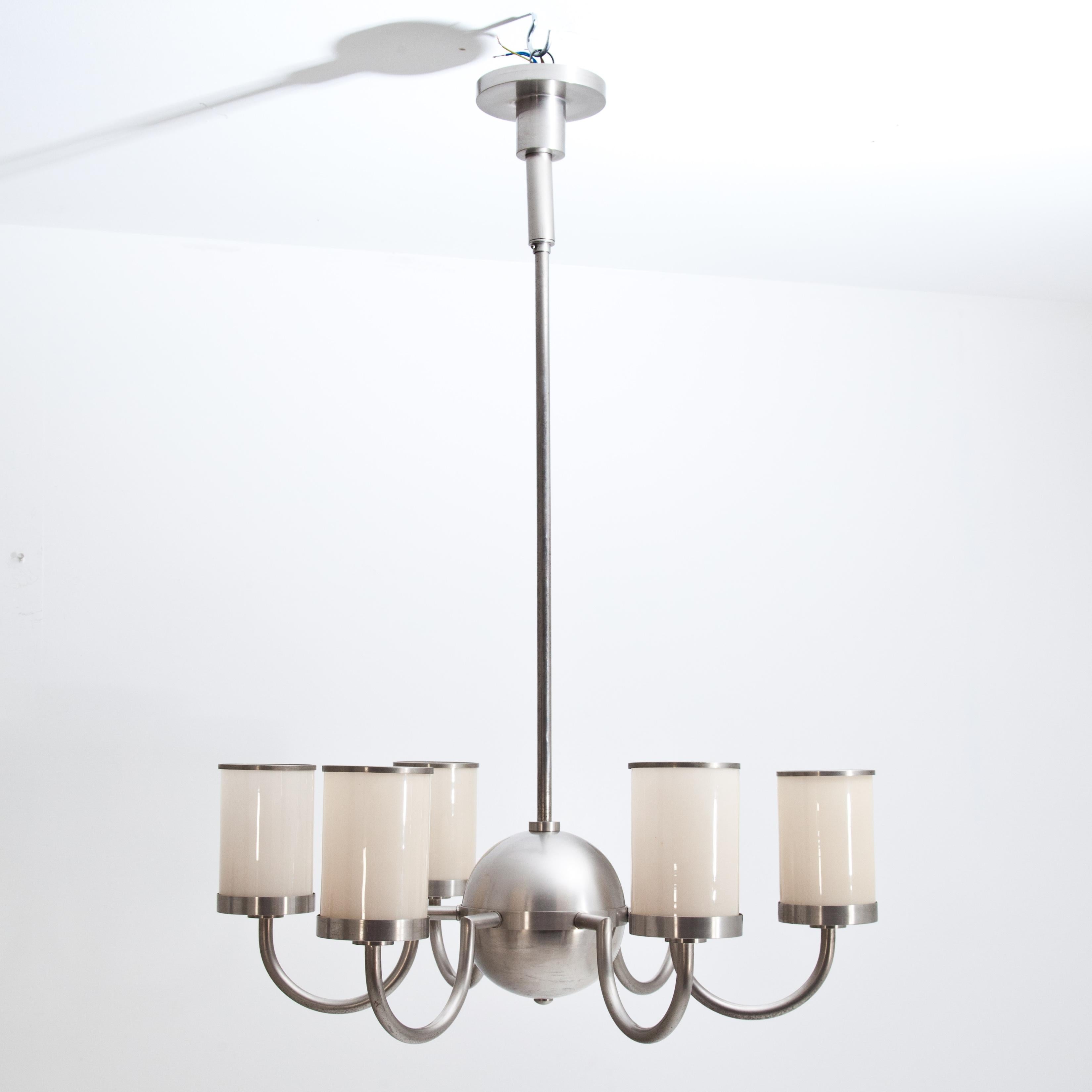 Six-armed Art Deco ceiling chandelier with cylindrical glass shades. The arched arms are grouped around the central spherical body, which is attached to a long metal rod.