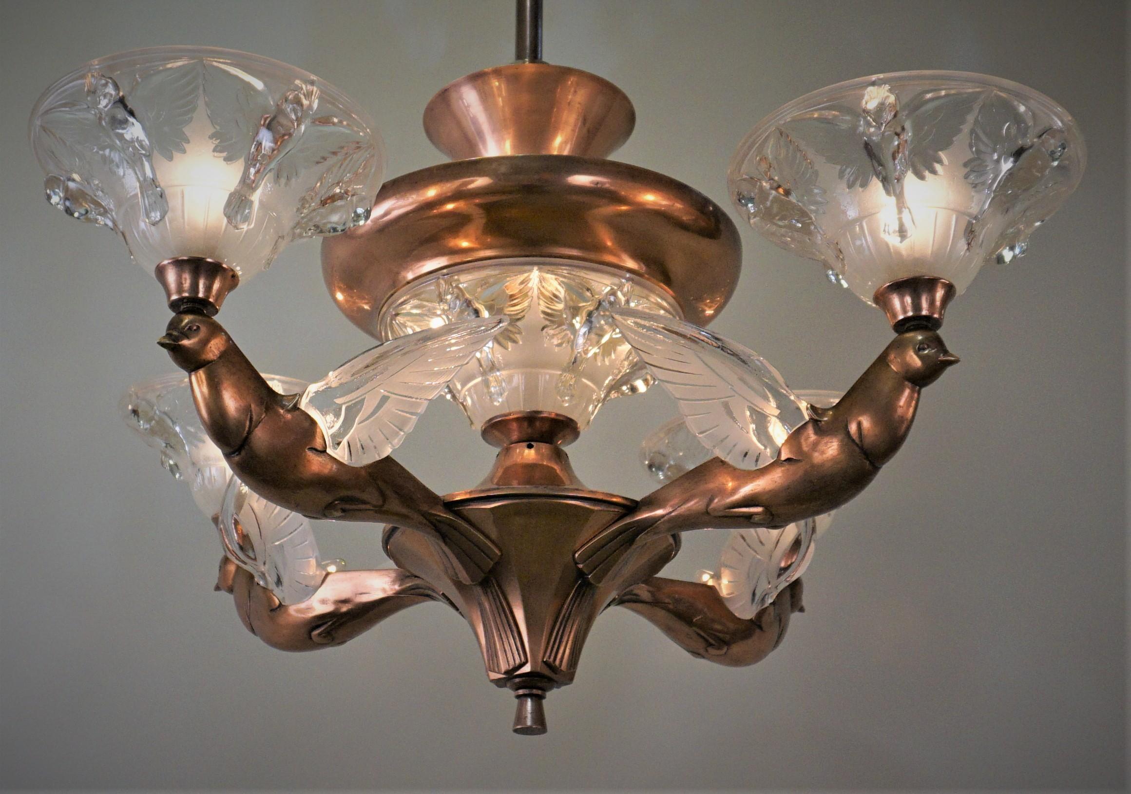 A superb four-arm copper over bronze art deco chandelier. Each arm is made in a shape of a bird which has glass wings with a light located in the center. This chandelier is a truly unique and elegant piece.